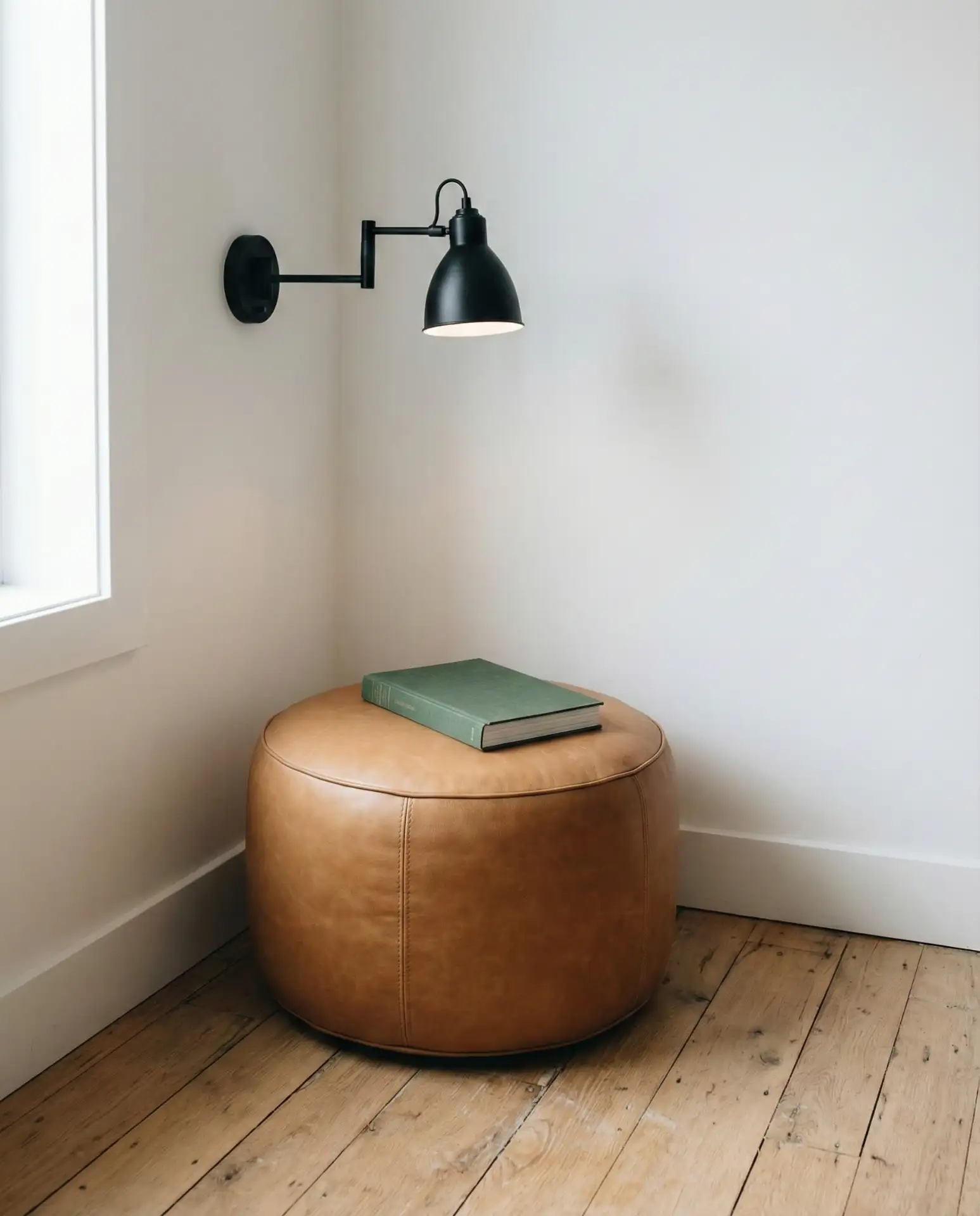 Minimalist Corner with Leather Pouf and Wall Sconce 1