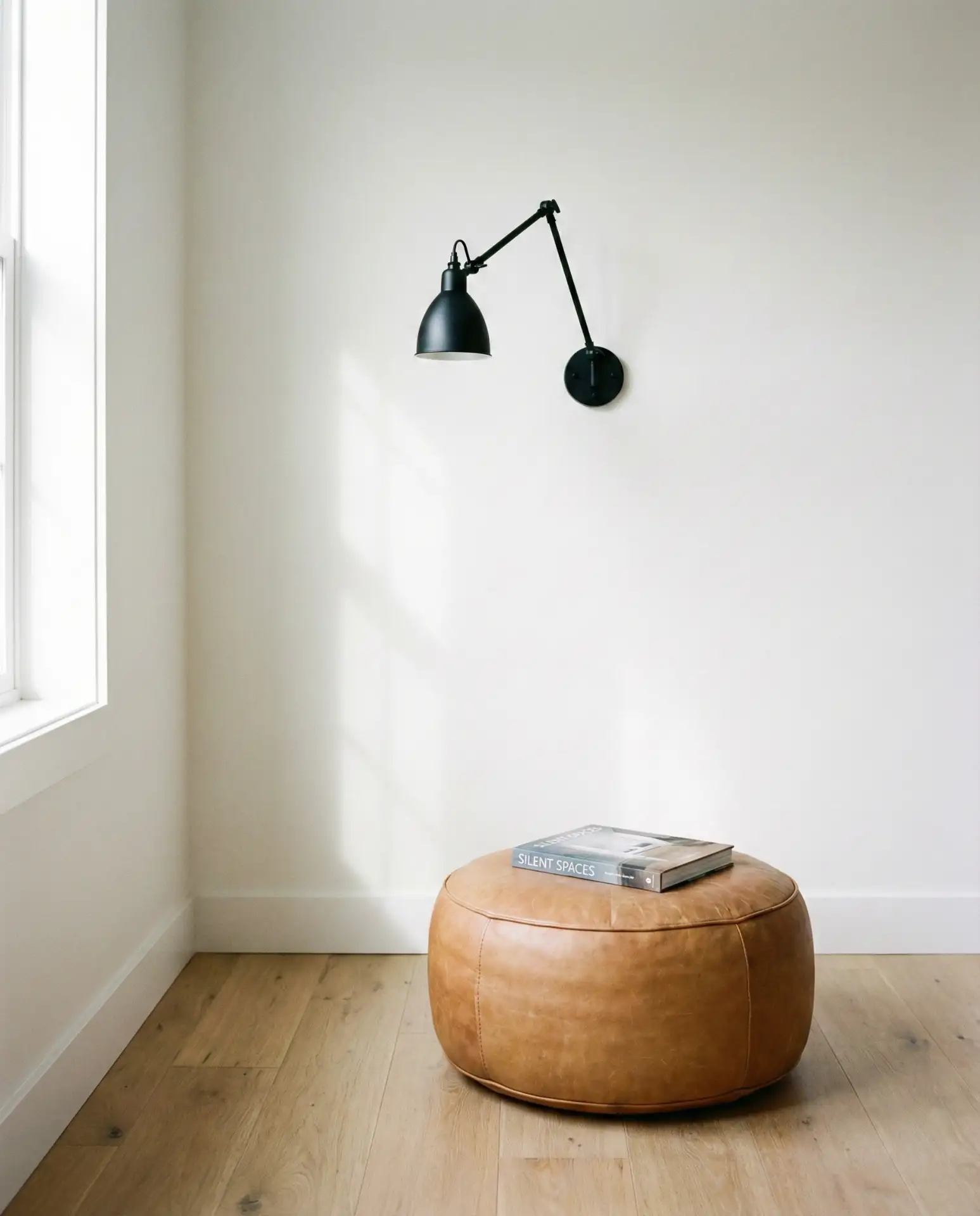 Minimalist Corner with Leather Pouf and Wall Sconce 2