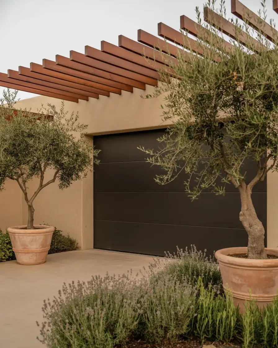Dark Painted Garage Door with Pergola and Potted Olive Trees 1