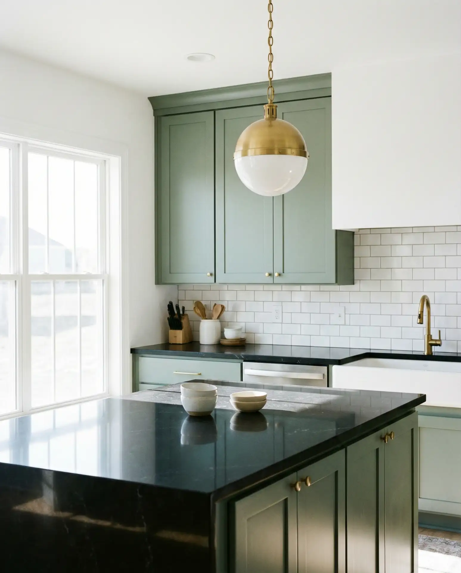 Sage Green Cabinets with Black Countertops and White Walls 1