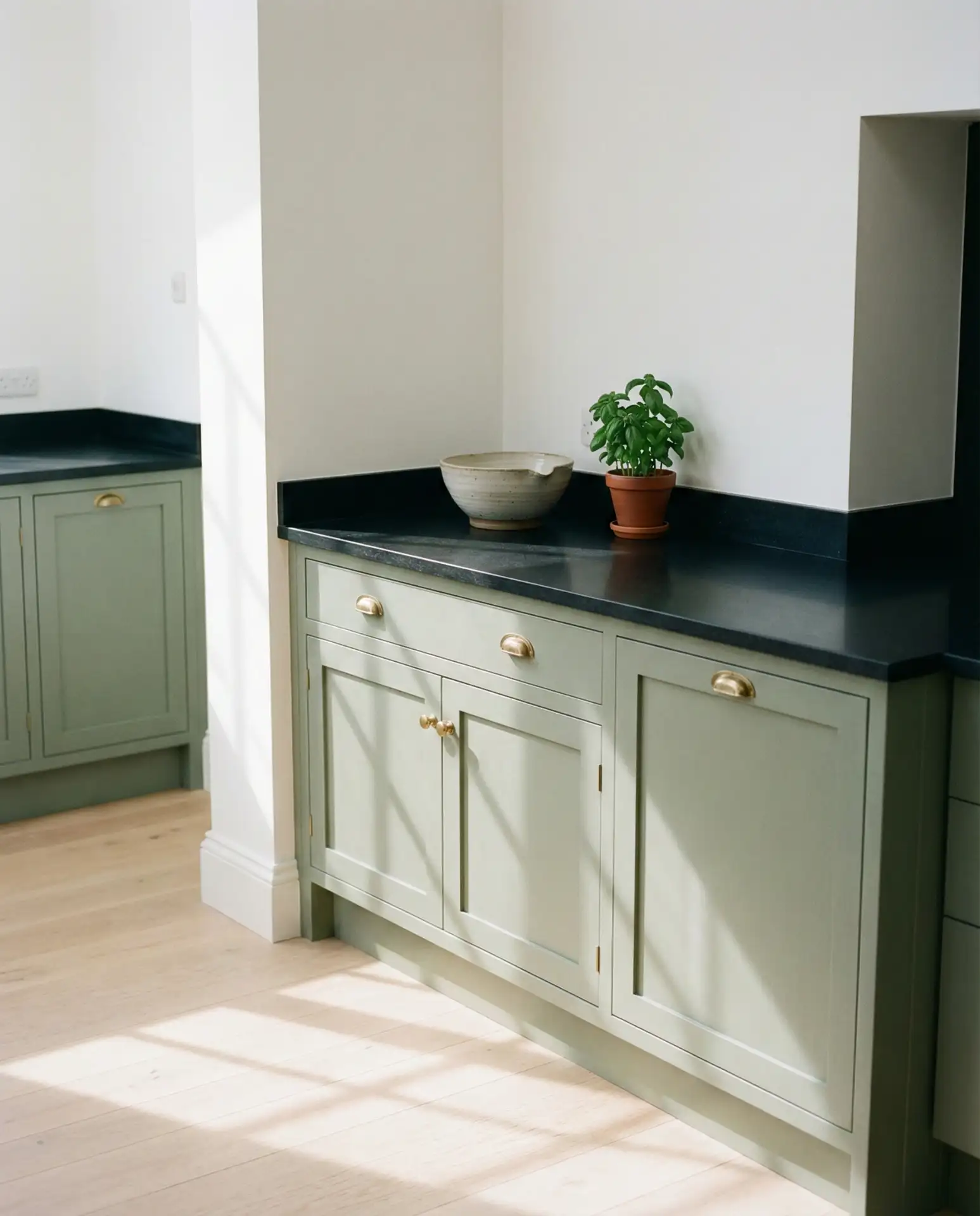 Sage Green Cabinets with Black Countertops and White Walls 2