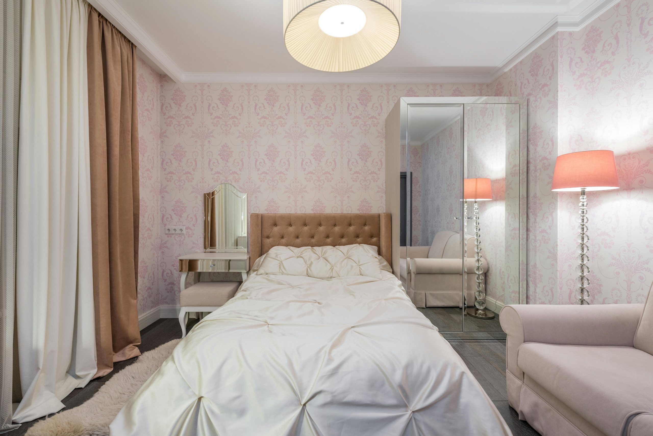 A modern, cozy bedroom featuring elegant decor with neutral tones and plush furniture.