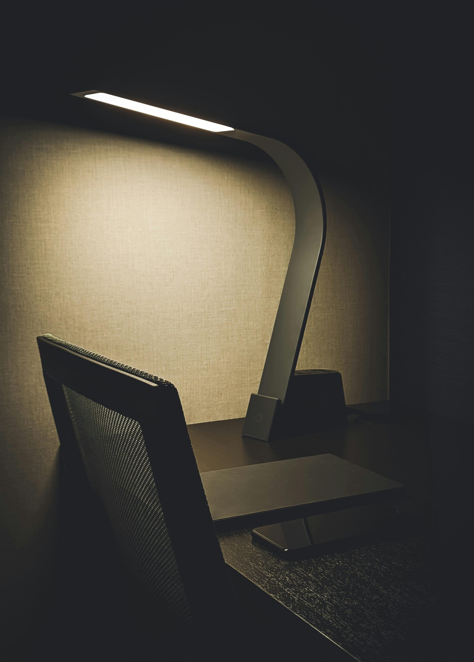 A modern office desk setup featuring a sleek lamp, perfect for minimalist interiors.