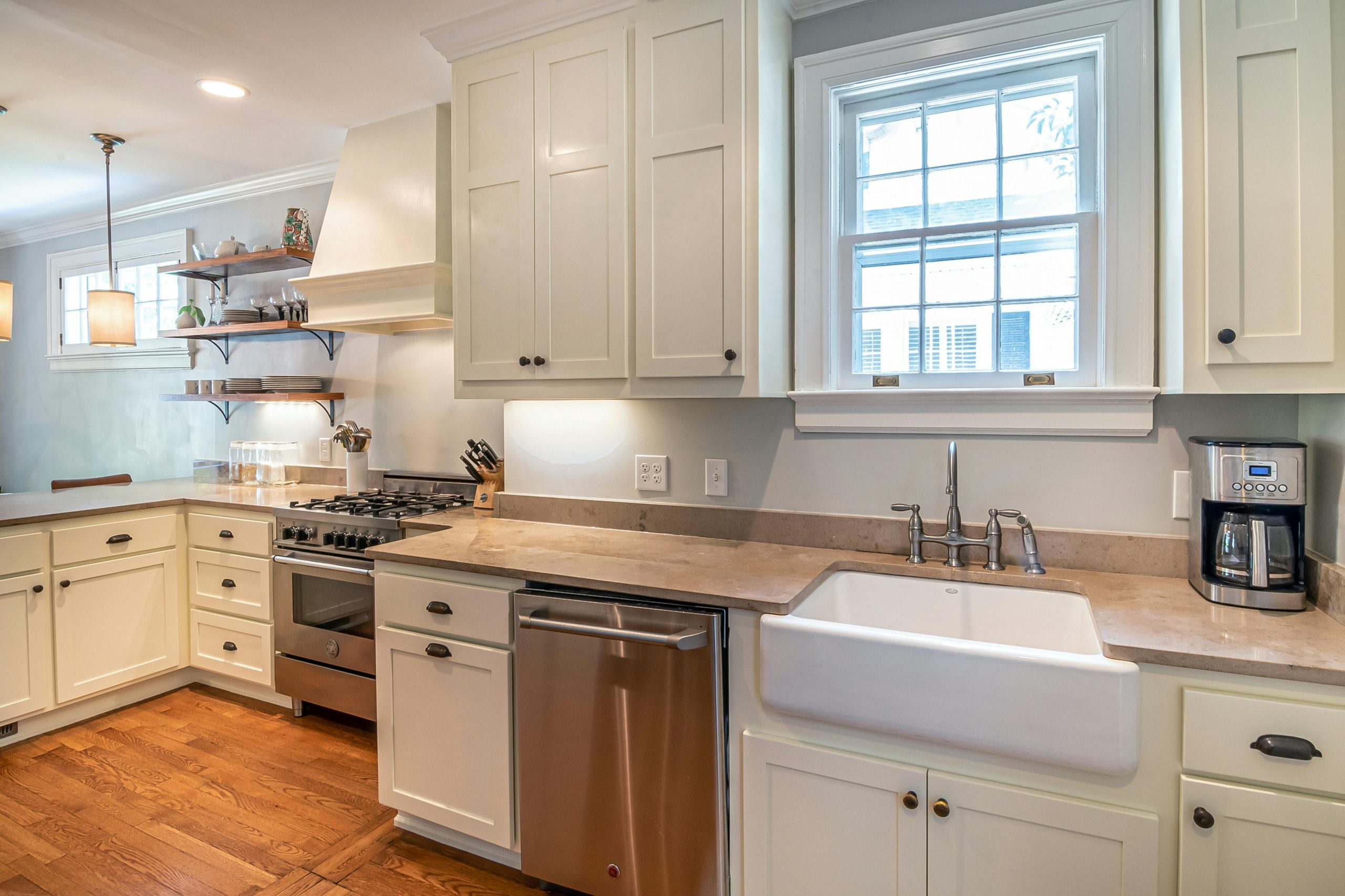 Bright kitchen with wooden floors and modern white cabinetry.