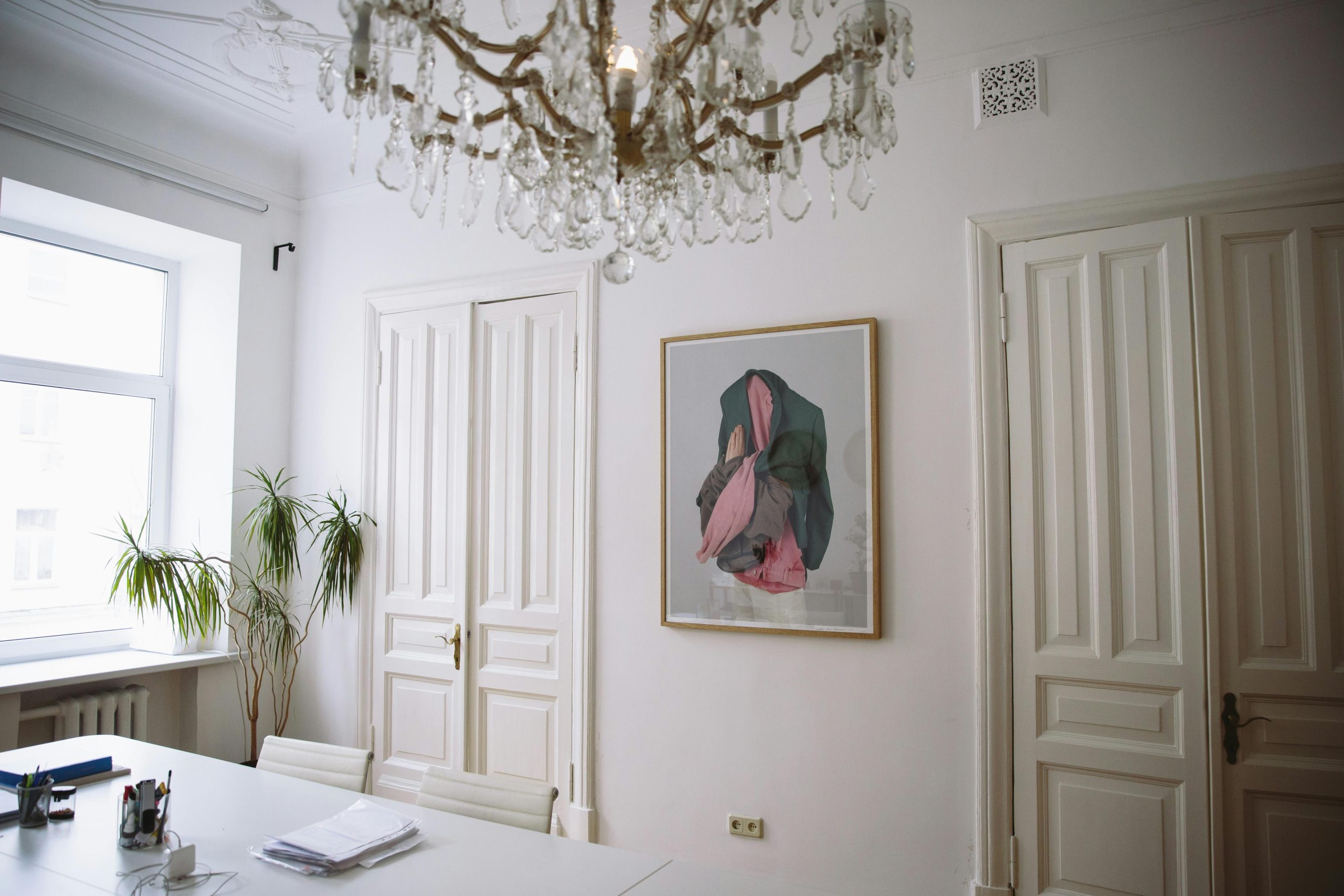 Bright office space featuring classic decor, a chandelier, and contemporary art.