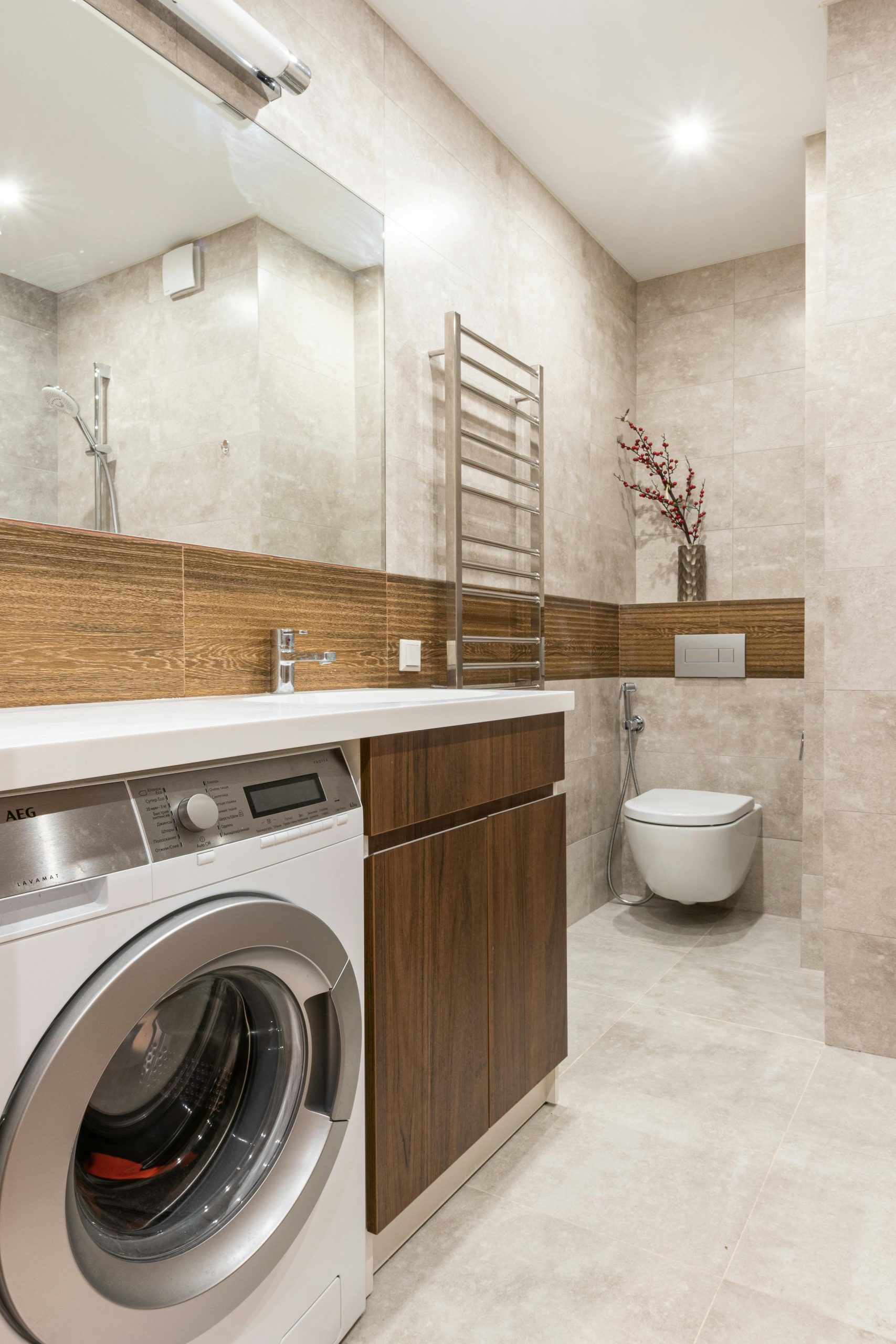 Contemporary bathroom interior featuring a washing machine, toilet bowl, and sleek design elements.