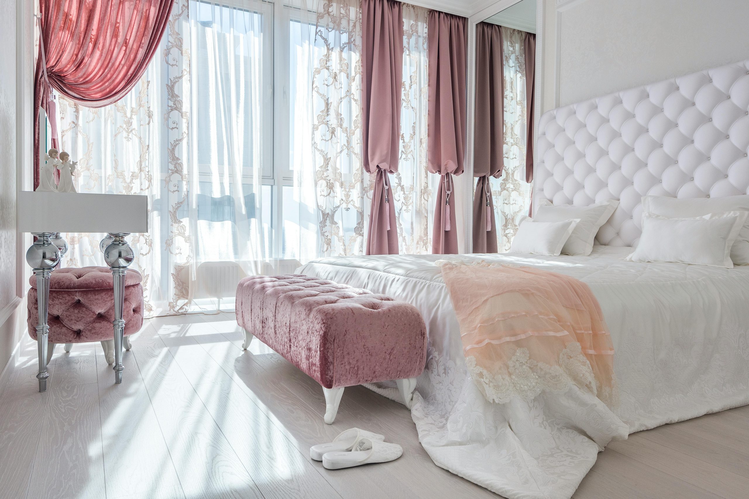 Elegant and cozy bedroom with pink velvet accents and soft lighting.