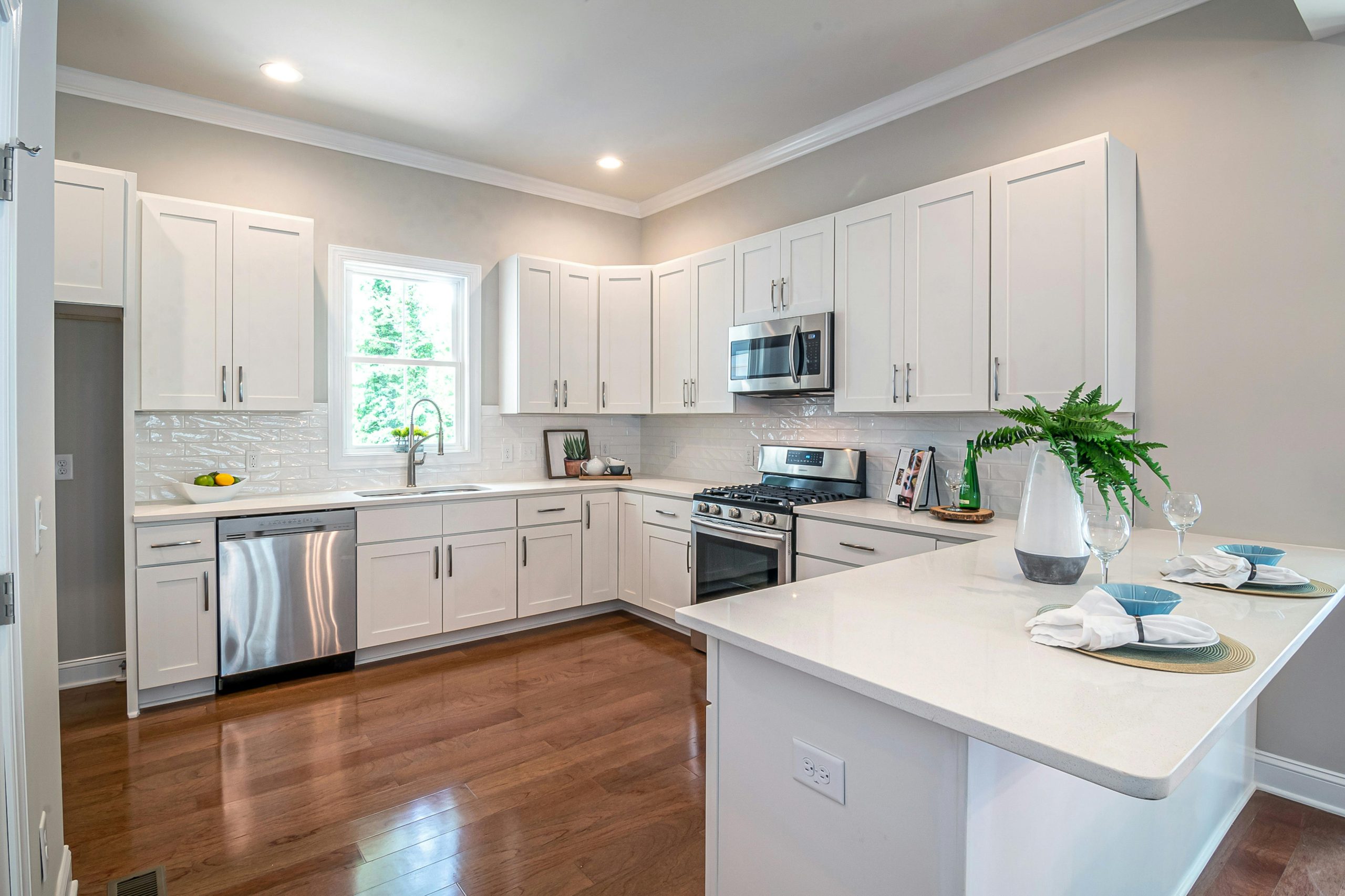 Spacious modern kitchen featuring white cabinets and appliances, perfect for home design.