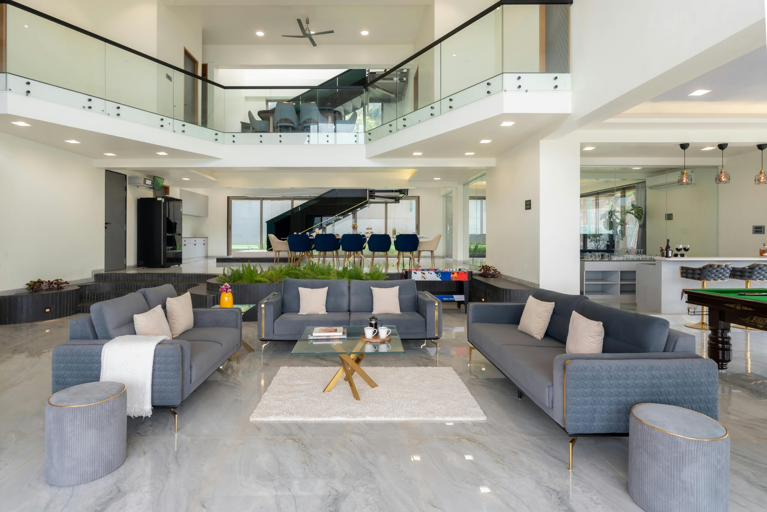 Spacious modern living room with elegant furnishings and open layout, featuring a mezzanine and stylish decor.