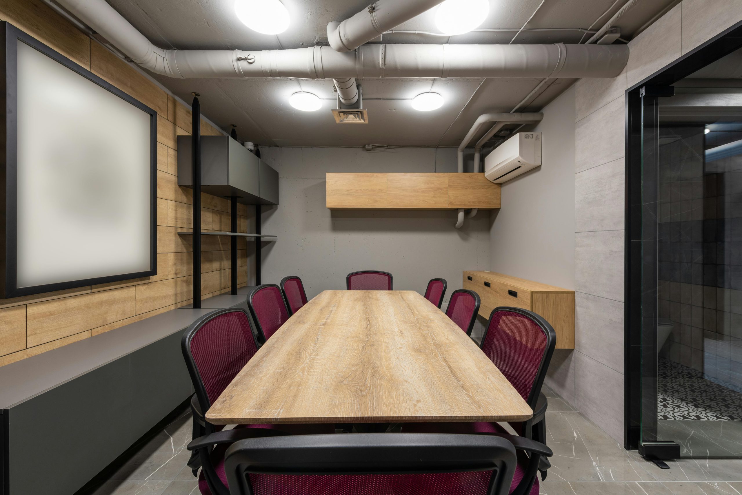Stylish modern conference room with wooden table and chairs, ideal for business meetings.