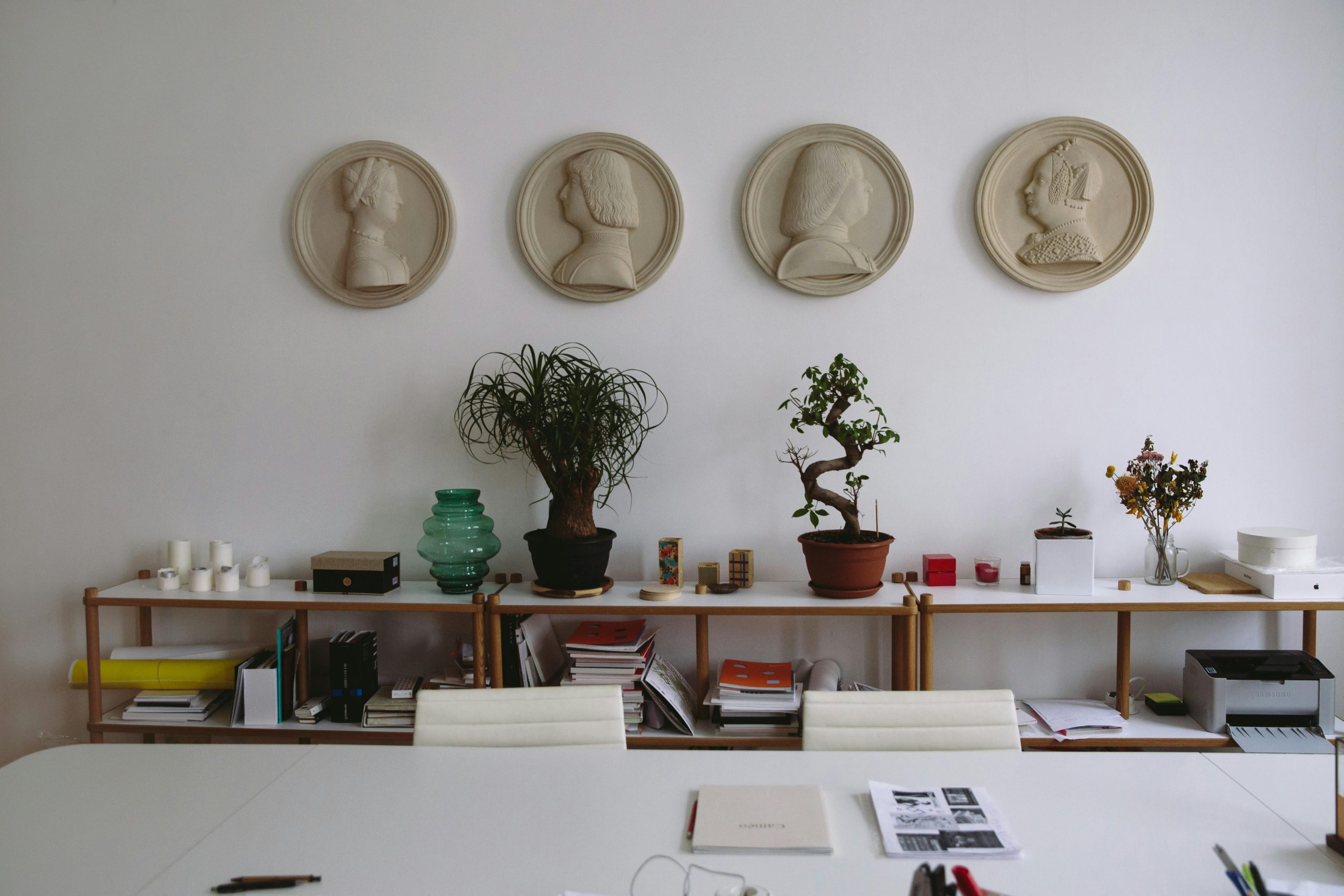 Stylish office interior featuring wall art, plants, and organized workspace essentials.