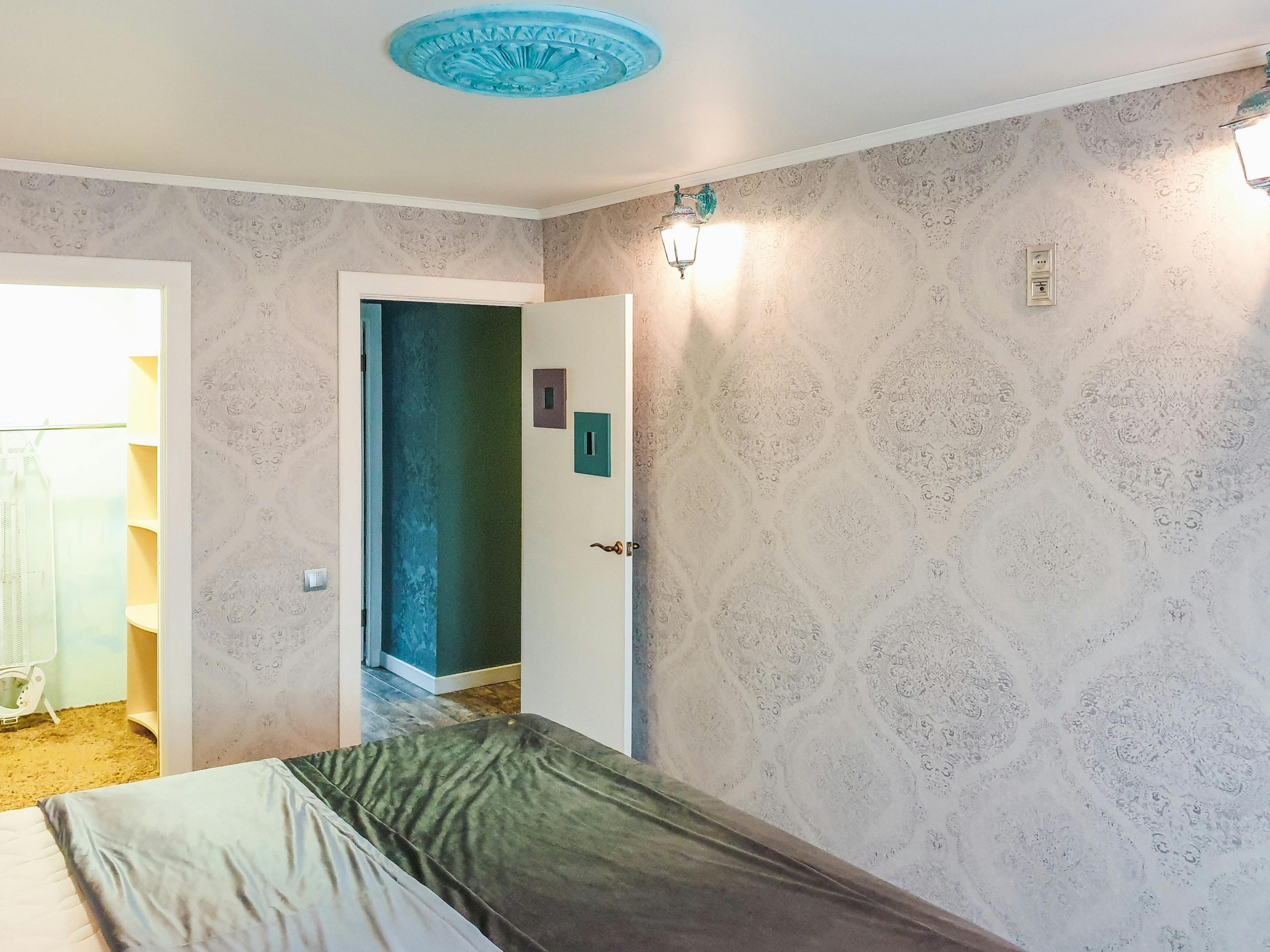 A bright and modern bedroom showcasing elegant wallpaper and sleek decor elements.