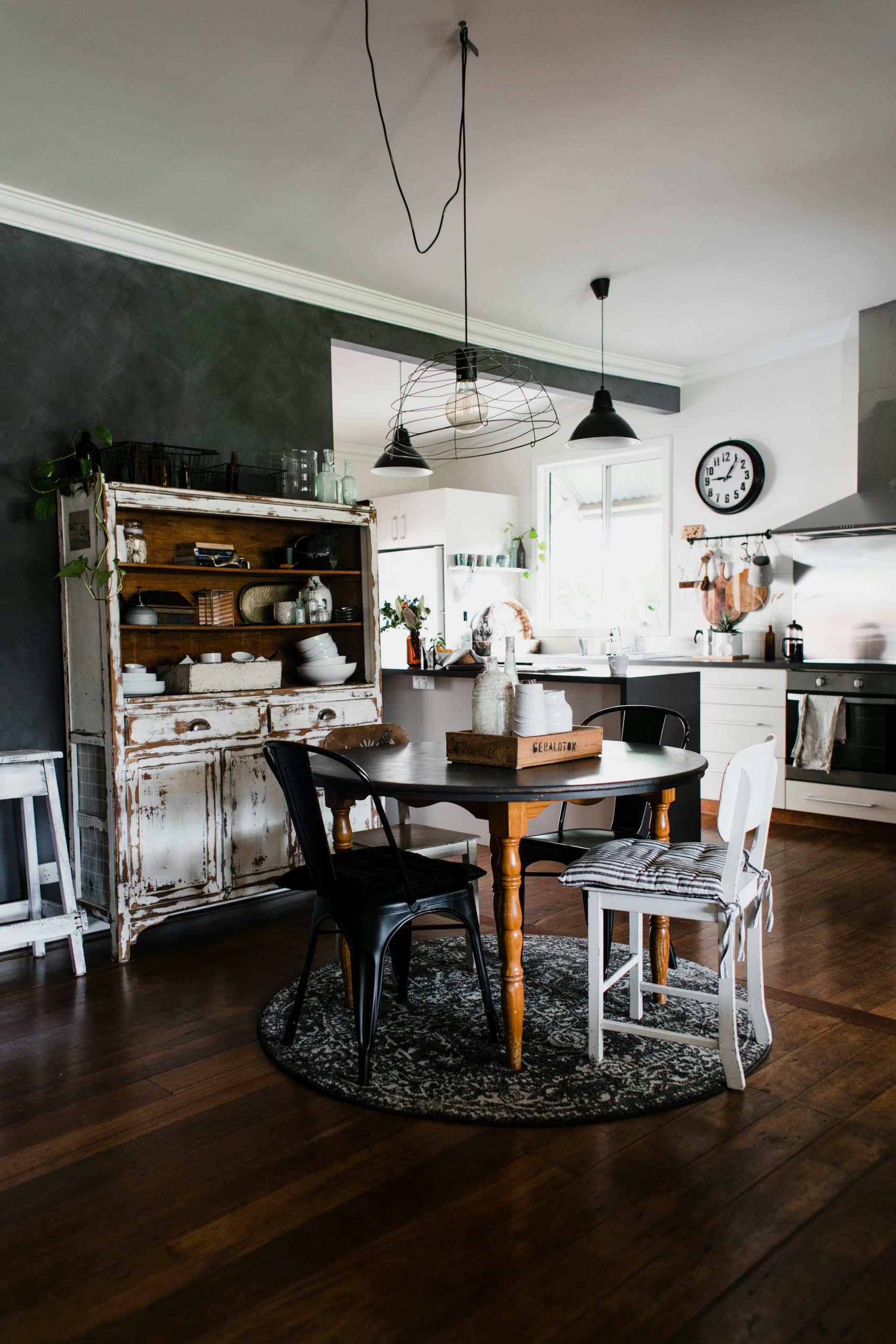 A cozy kitchen blending rustic and modern elements with vintage furniture and warm tones.