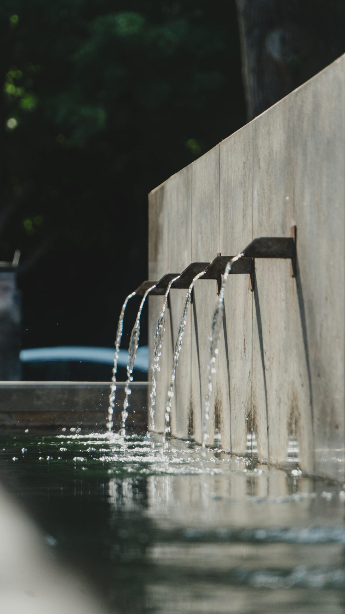 A serene concrete water feature in an outdoor park setting, ideal for relaxation.