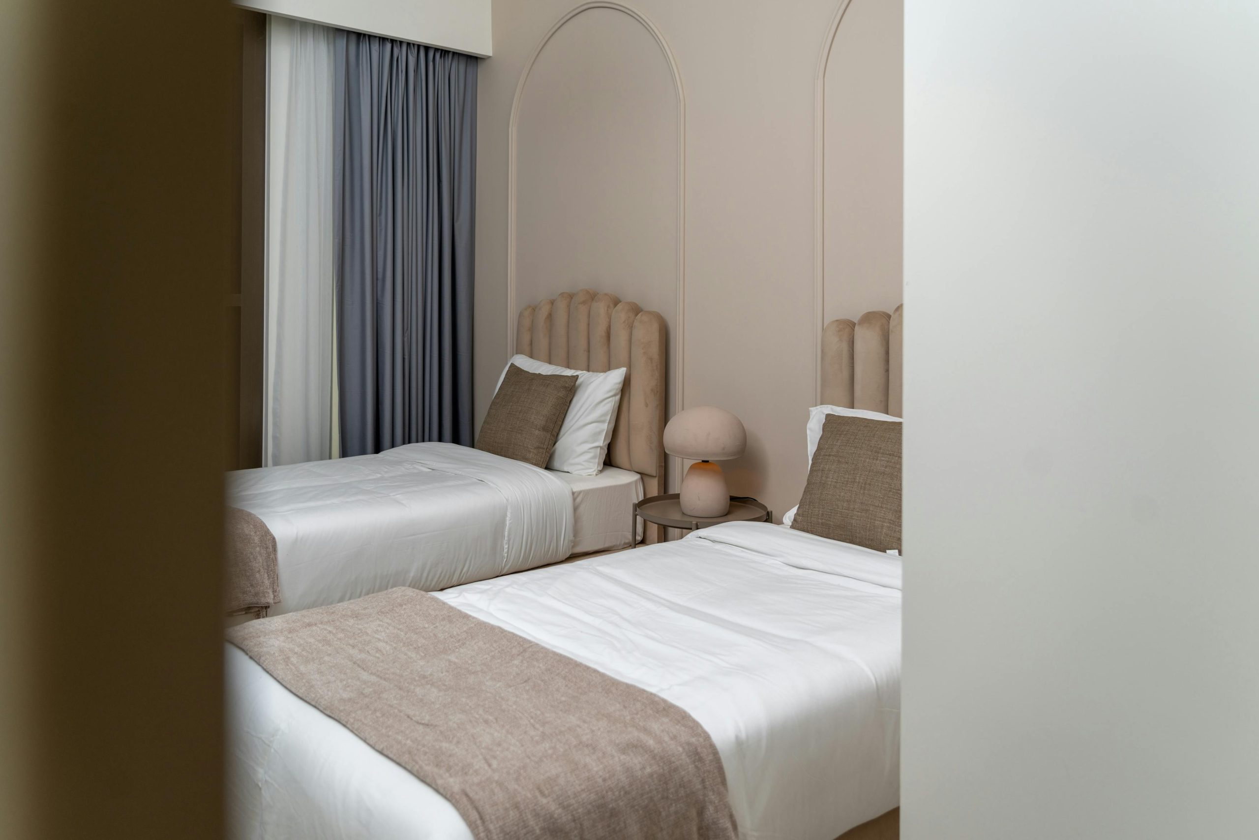 A sleek and modern twin bed setup in a luxury hotel in Dubai.