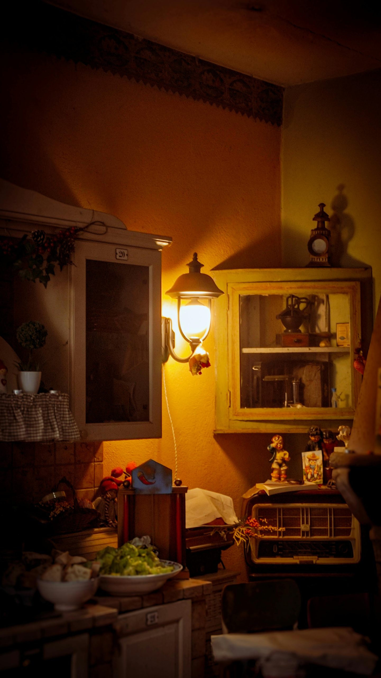 Atmospheric vintage kitchen interior with rustic cabinets and warm lamp light.