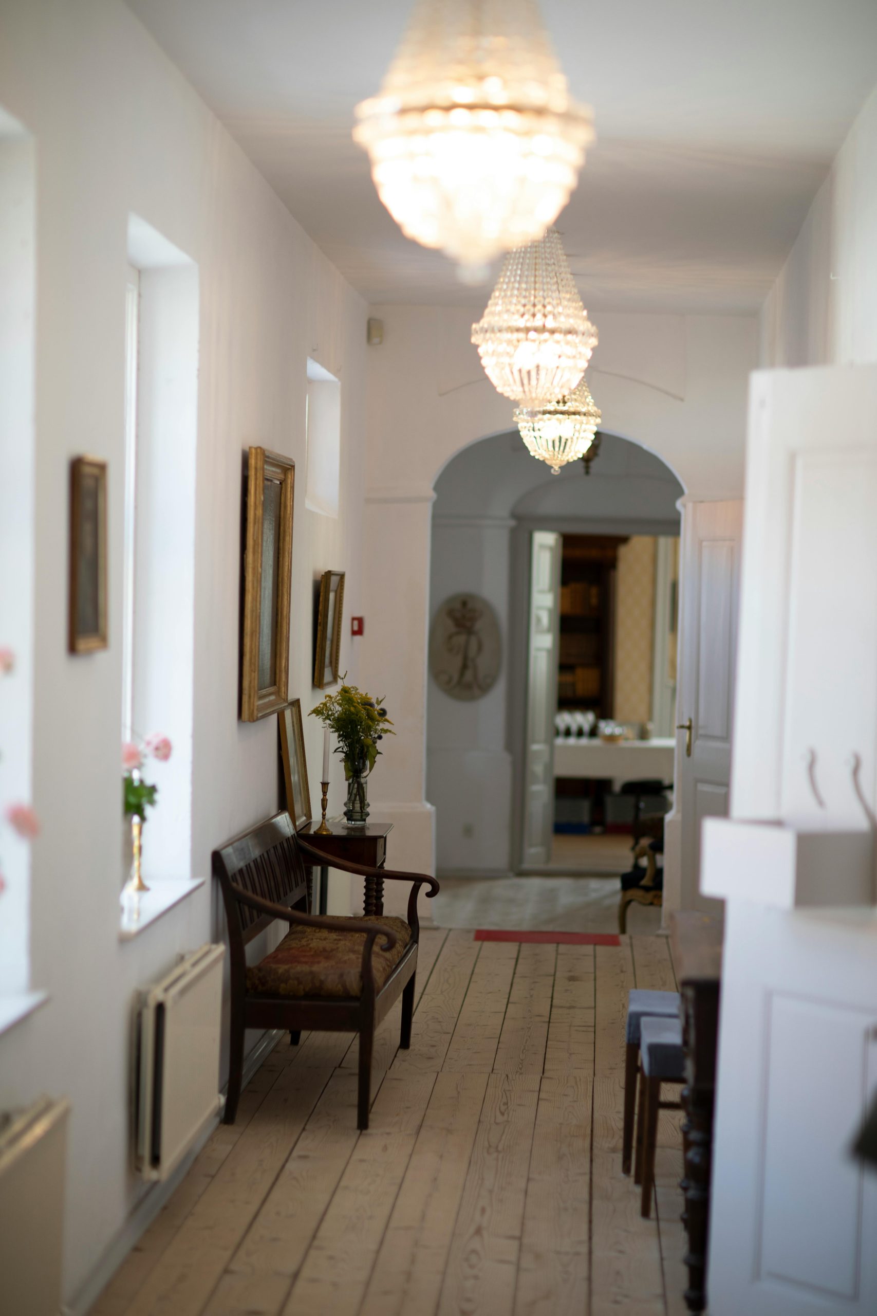 Charming home hallway featuring vintage furniture, artwork, and decorative lighting.