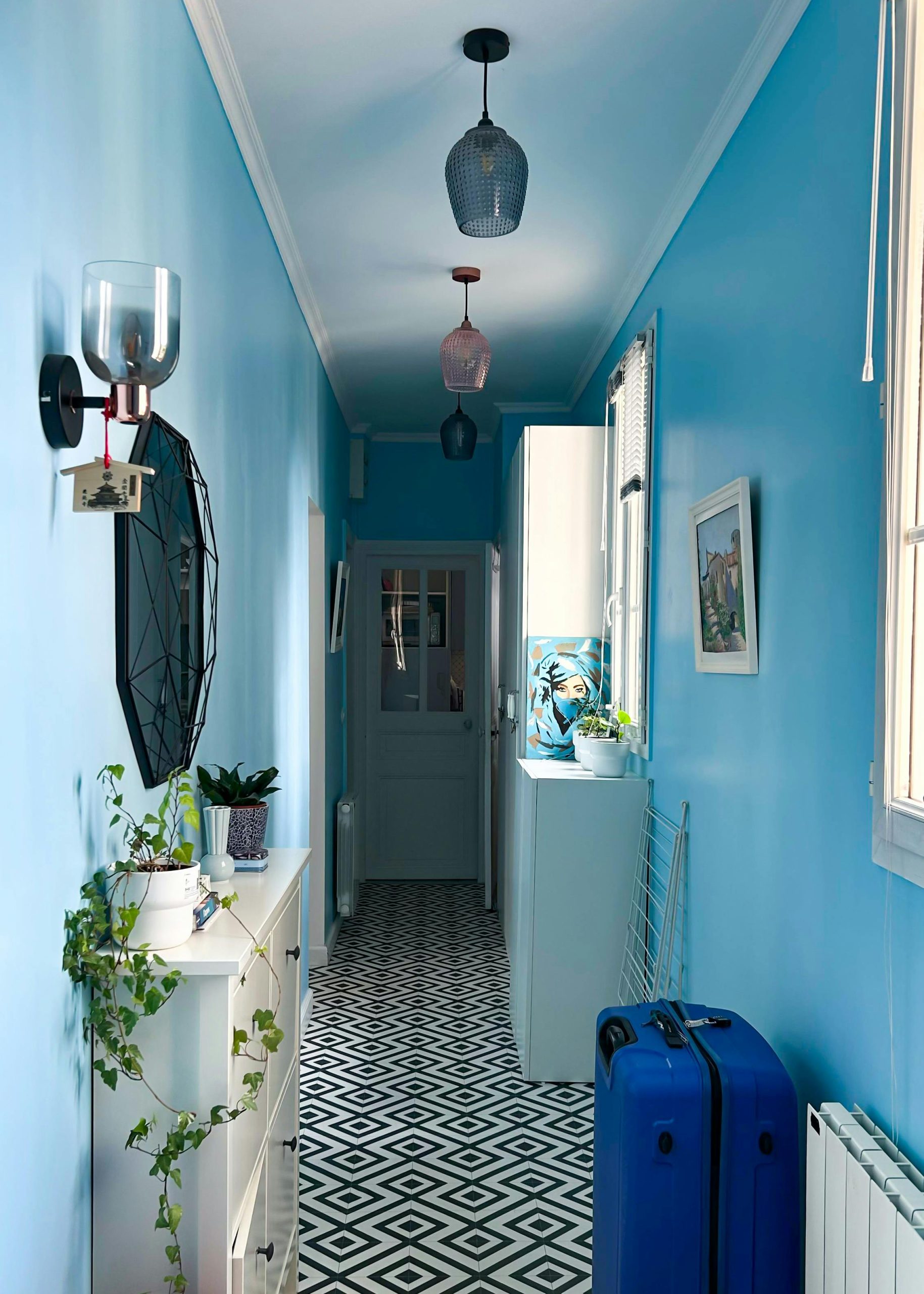 Chic blue hallway with decor, indoor plants, and patterned floor in Paris apartment, IDF, France.