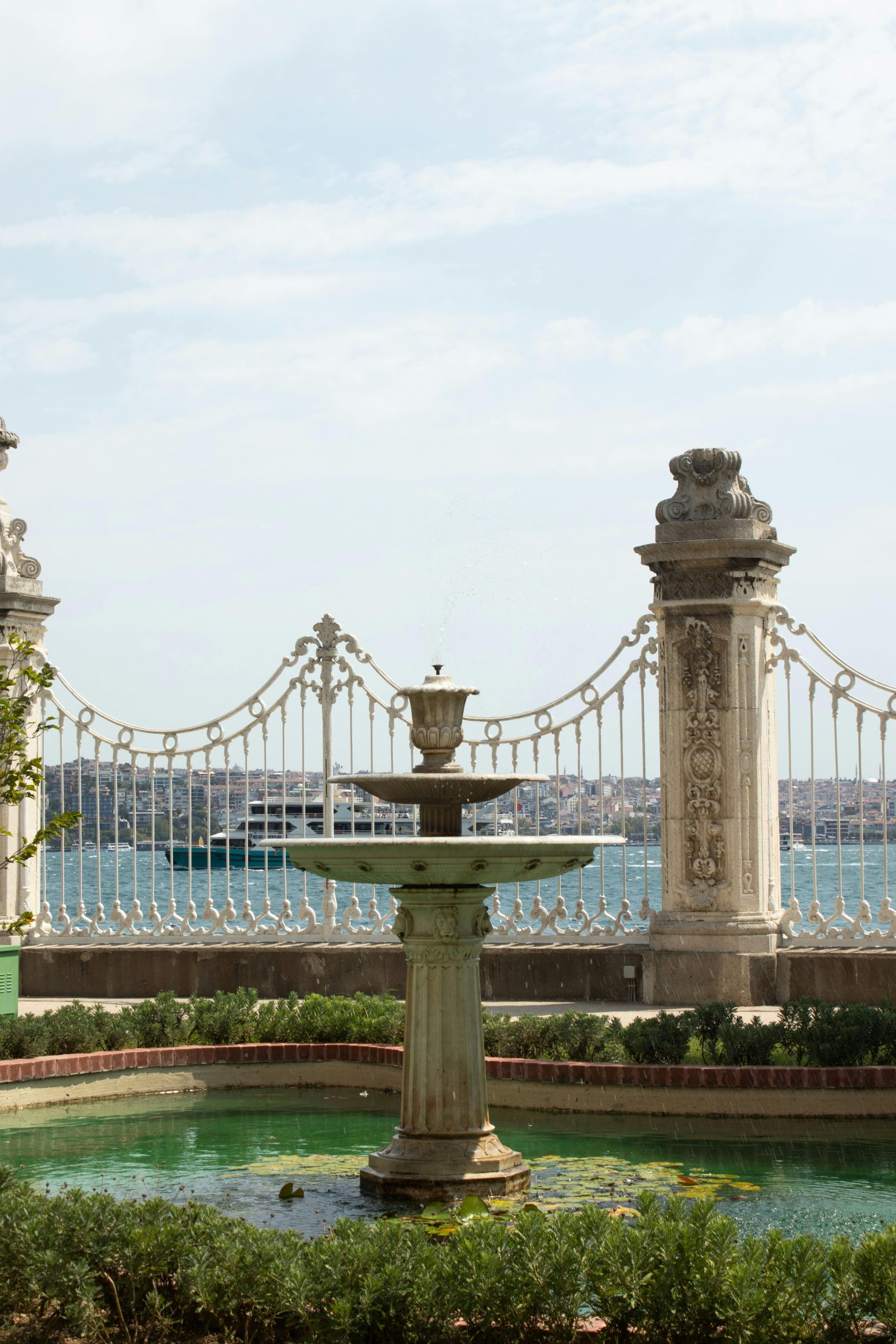 Classic stone fountain with elegant railing and water view, ideal for travel and architecture themes.