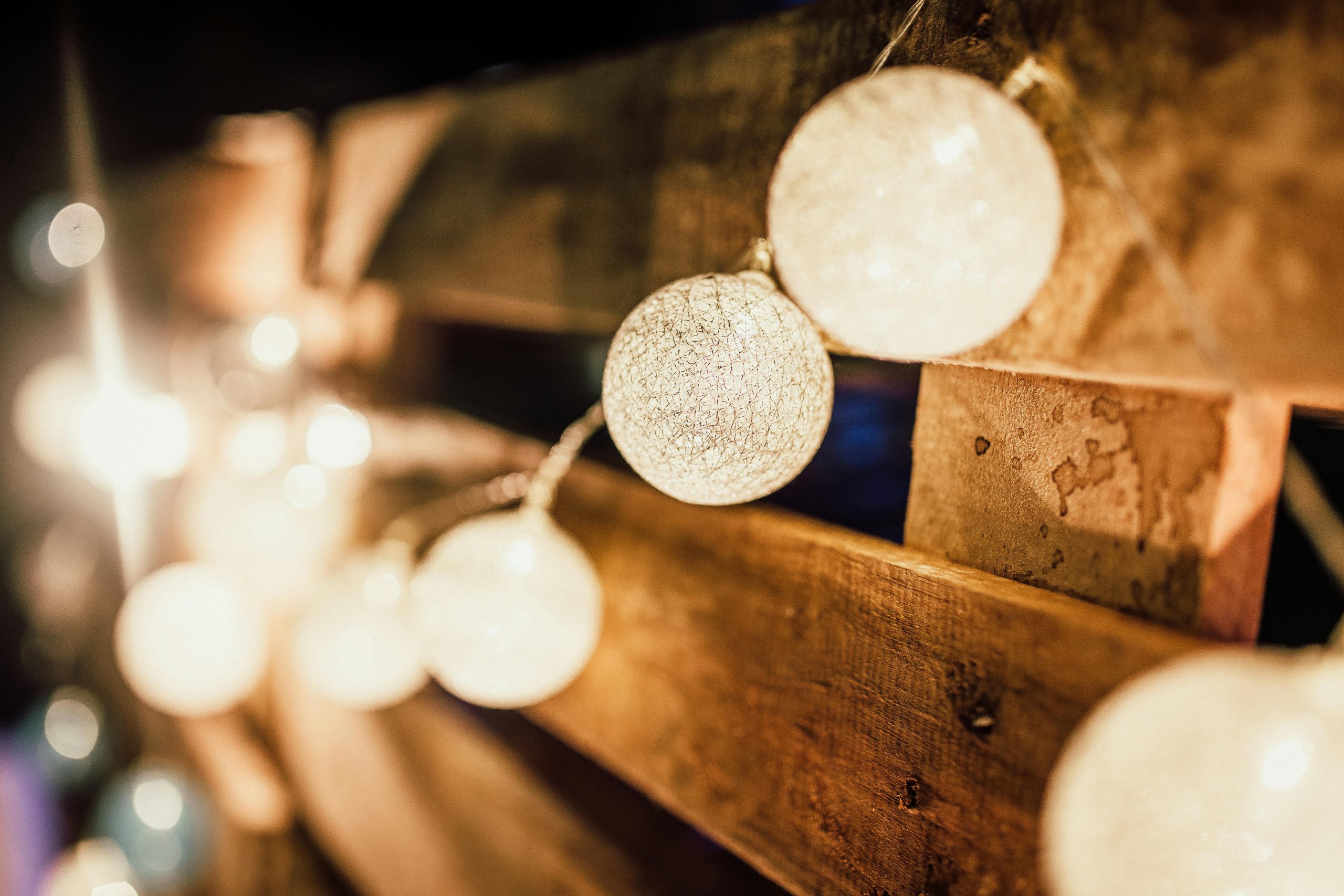 Cozy and warm atmosphere created by string lights against a wooden backdrop.
