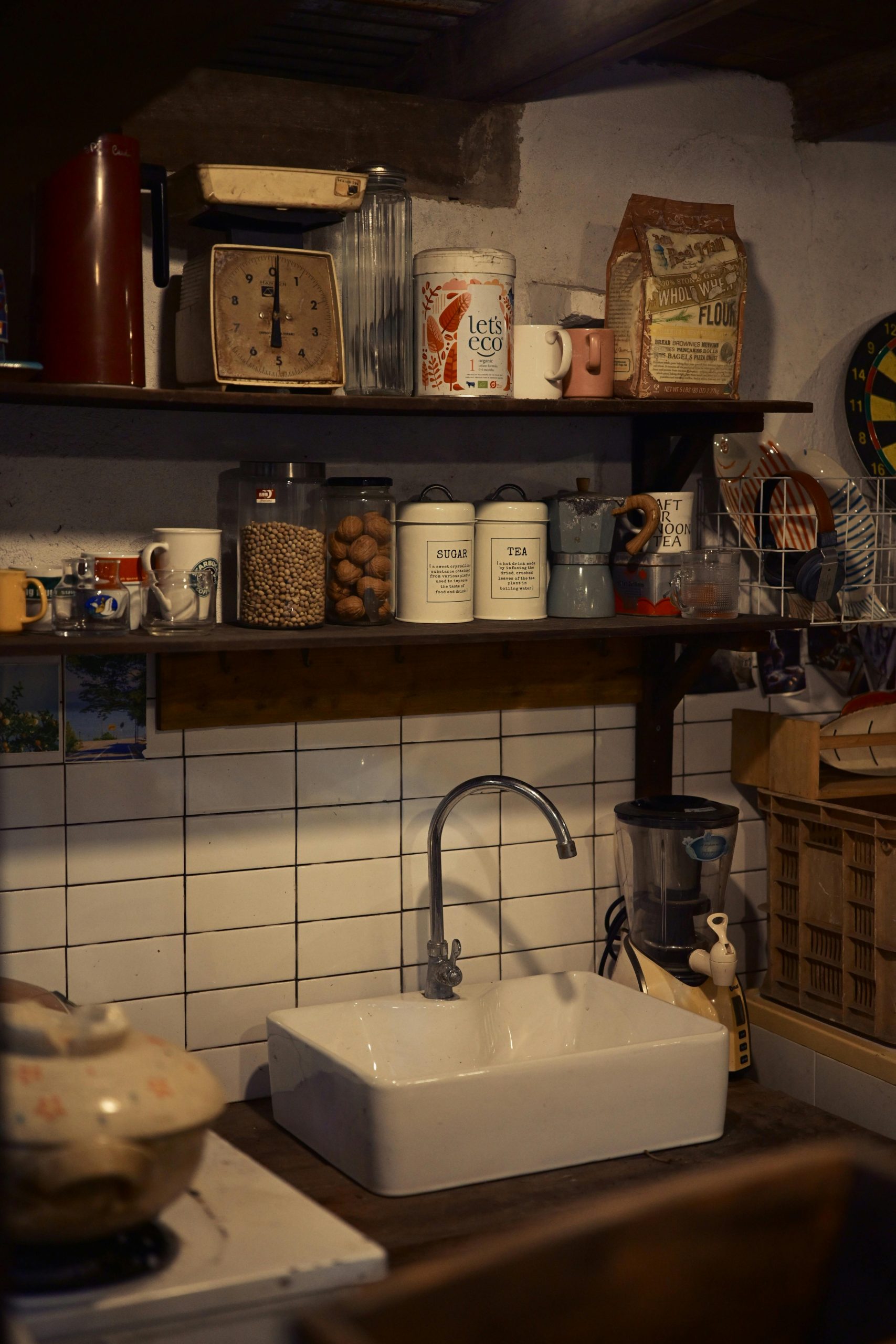 Cozy rustic kitchen featuring vintage utensils, open shelves, and farmhouse style sink.