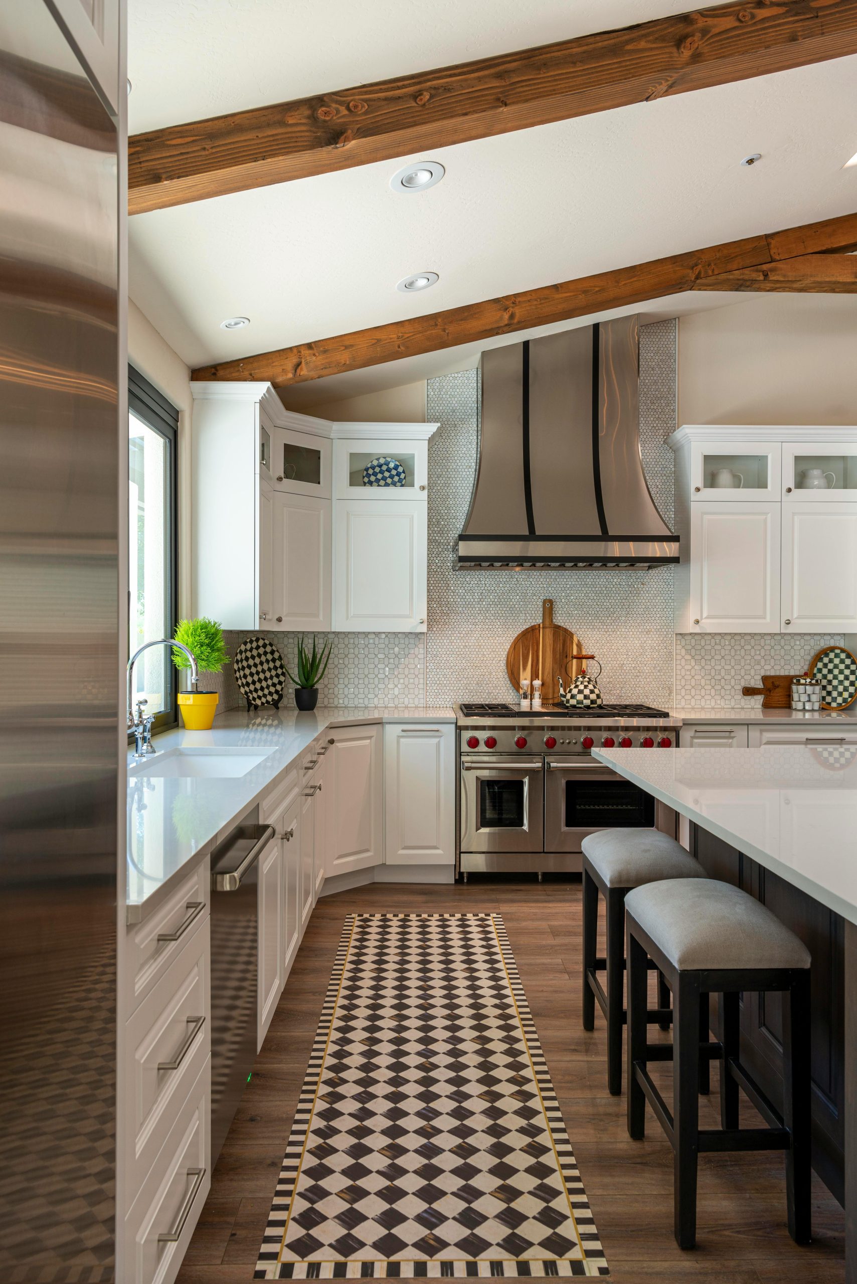 Elegant modern farmhouse kitchen with island, bar stools, and wooden beams.