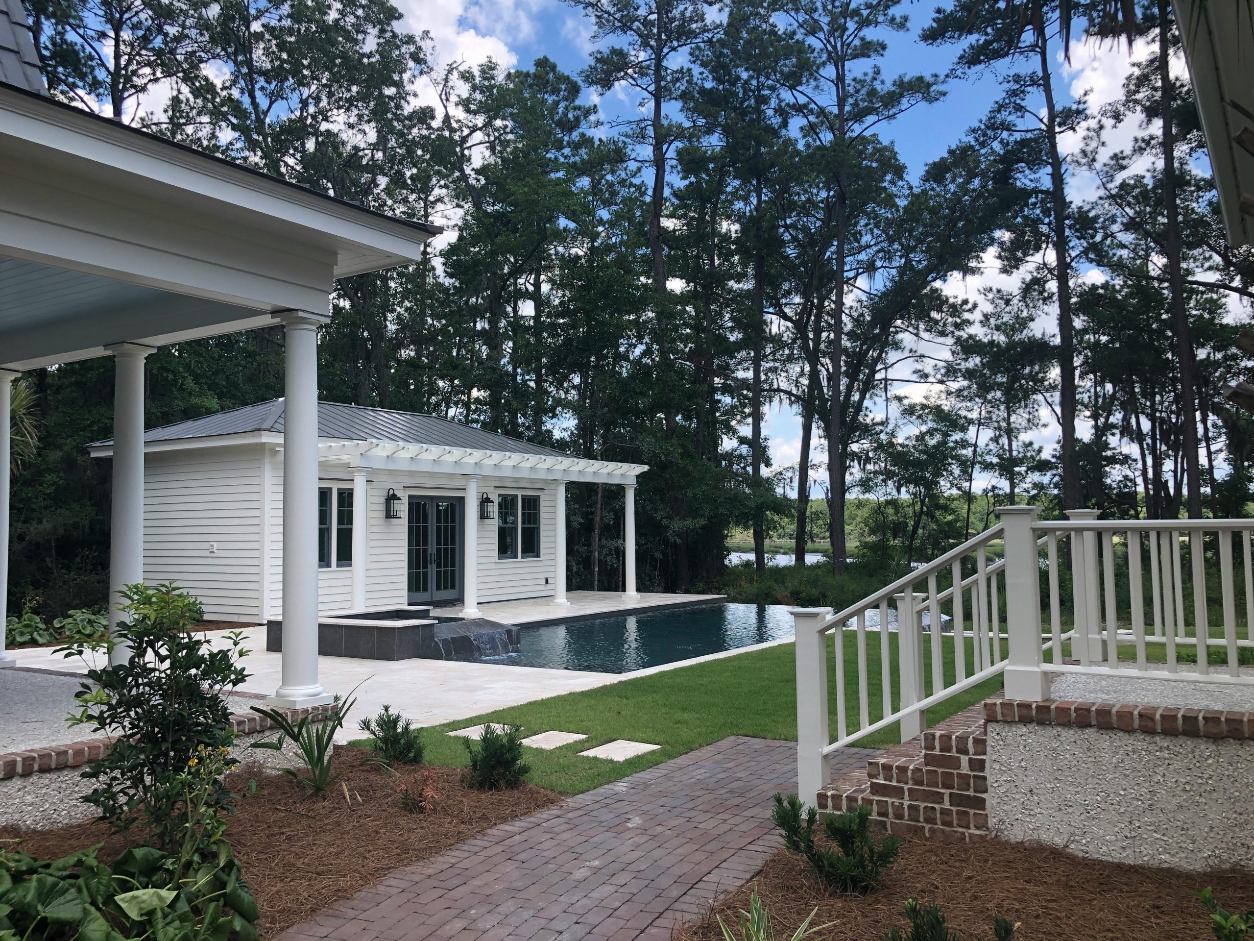 Explore a serene backyard with infinity pool surrounded by trees in Bluffton, SC. Perfect for relaxation.