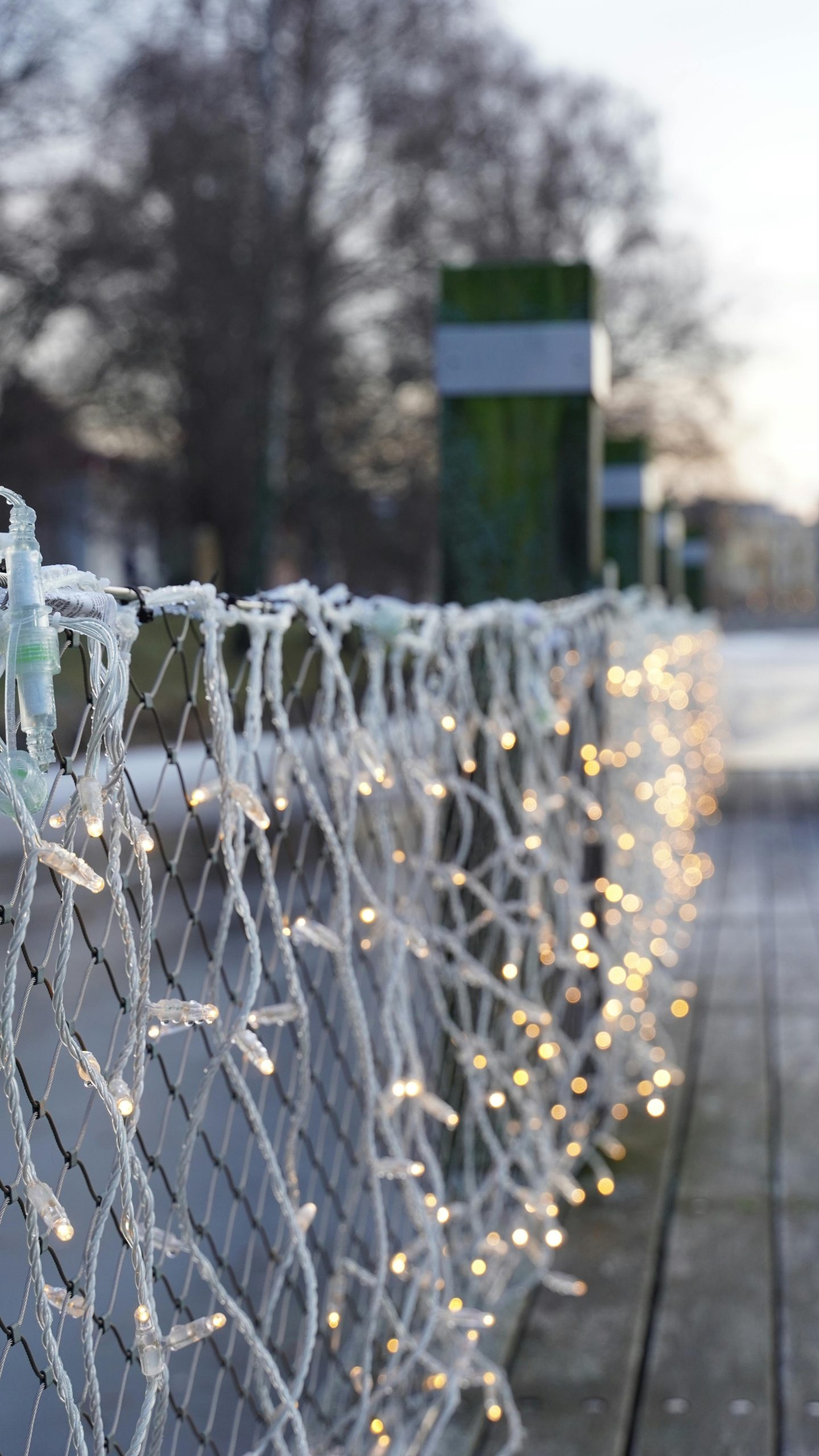 Festive string lights adorn a wooden fence in snowy Karlstad, Sweden, creating a cozy winter ambiance.