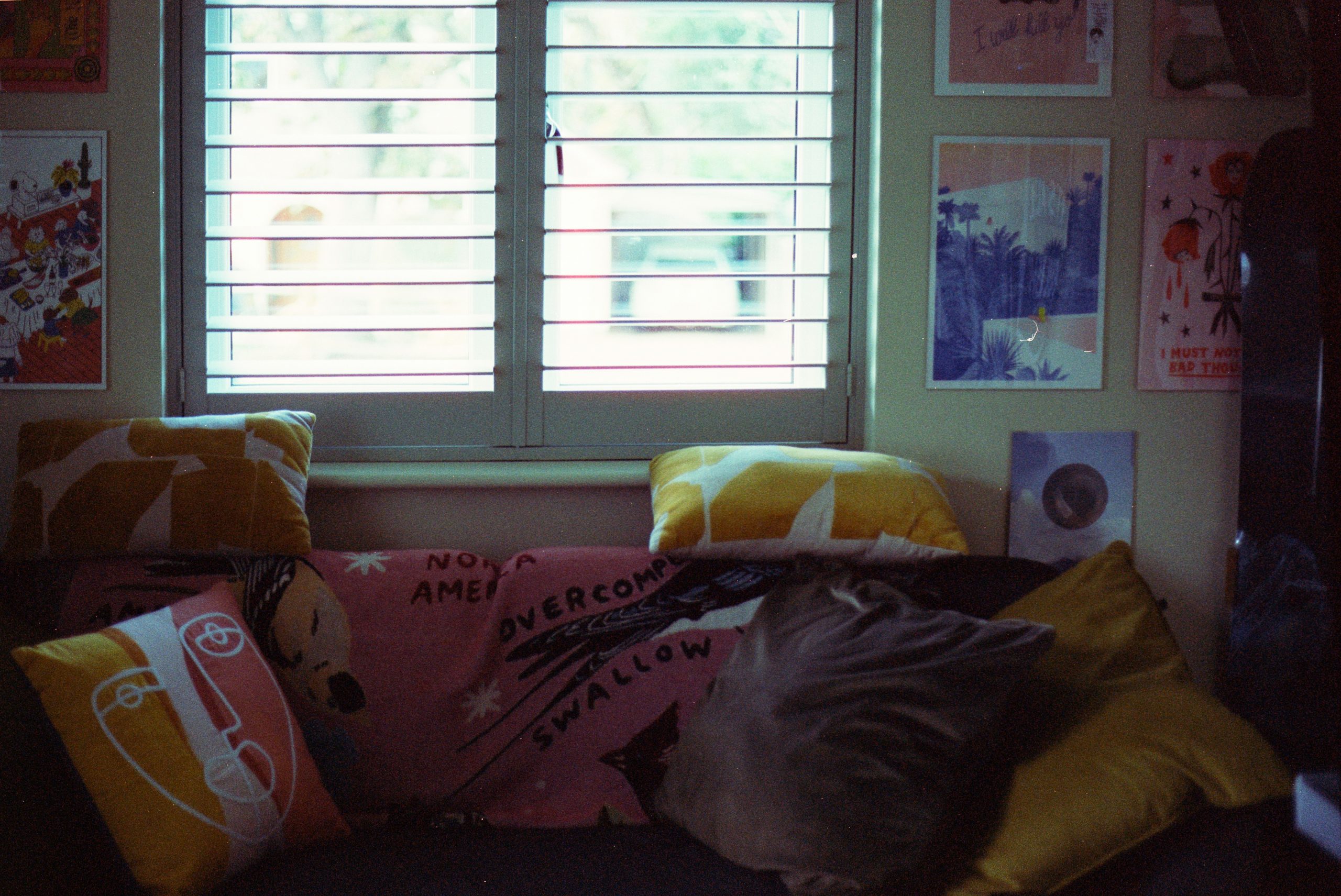 Sofa with colorful pillows and artwork by window