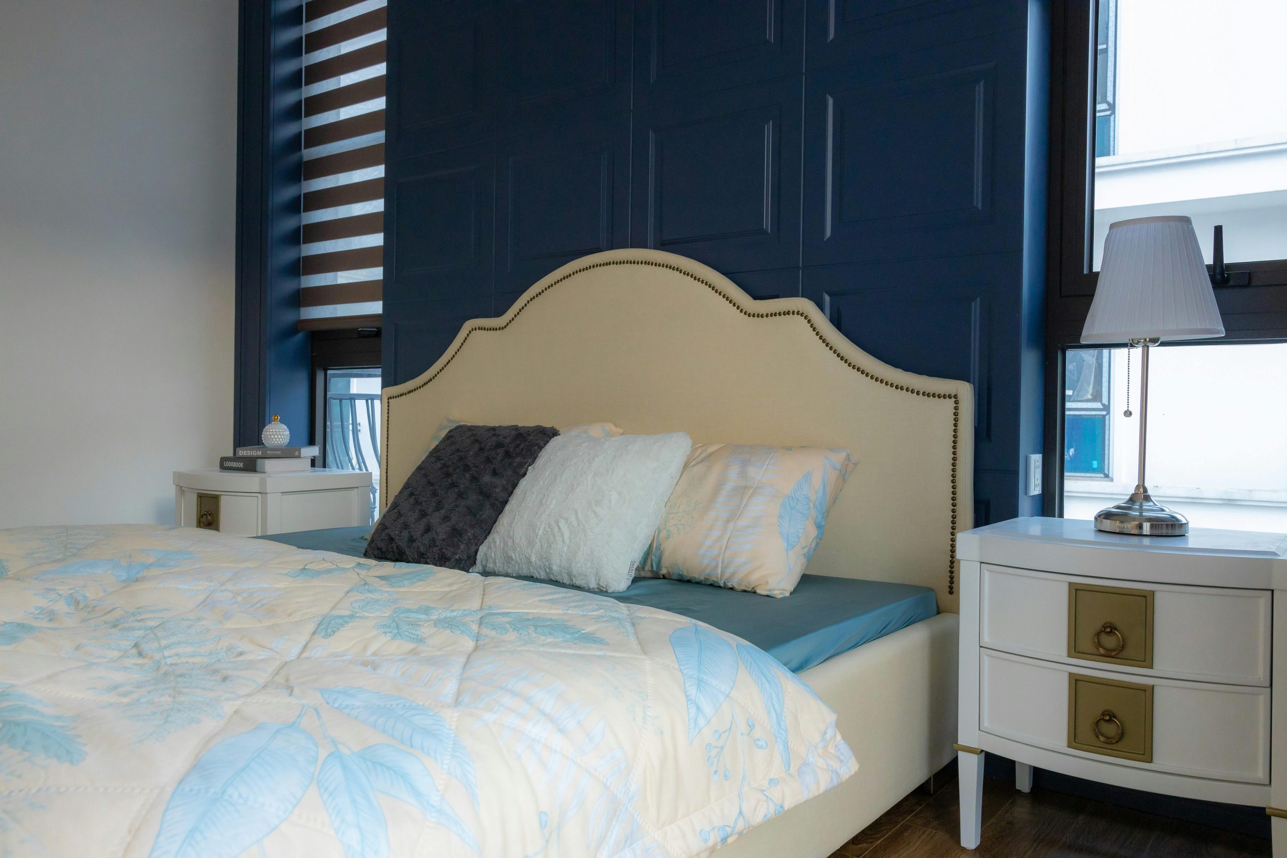 Stylish bedroom with a chic blue accent wall and elegant decor.