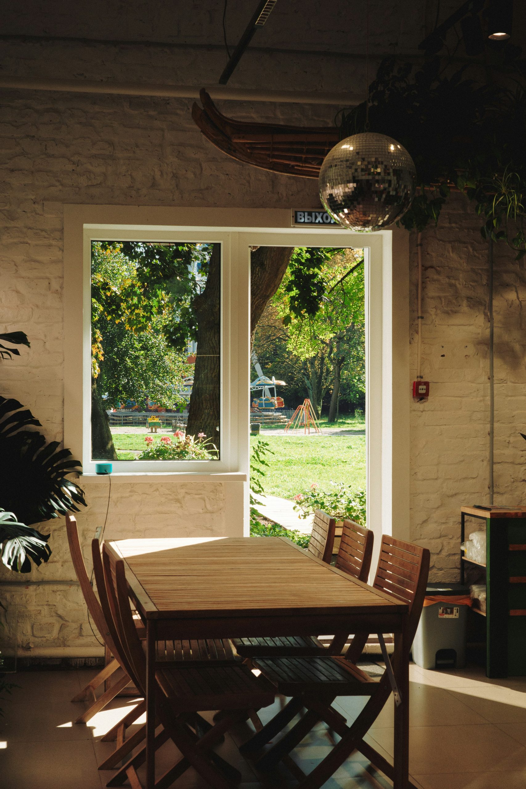 Wooden table and chairs near a window overlooking garden