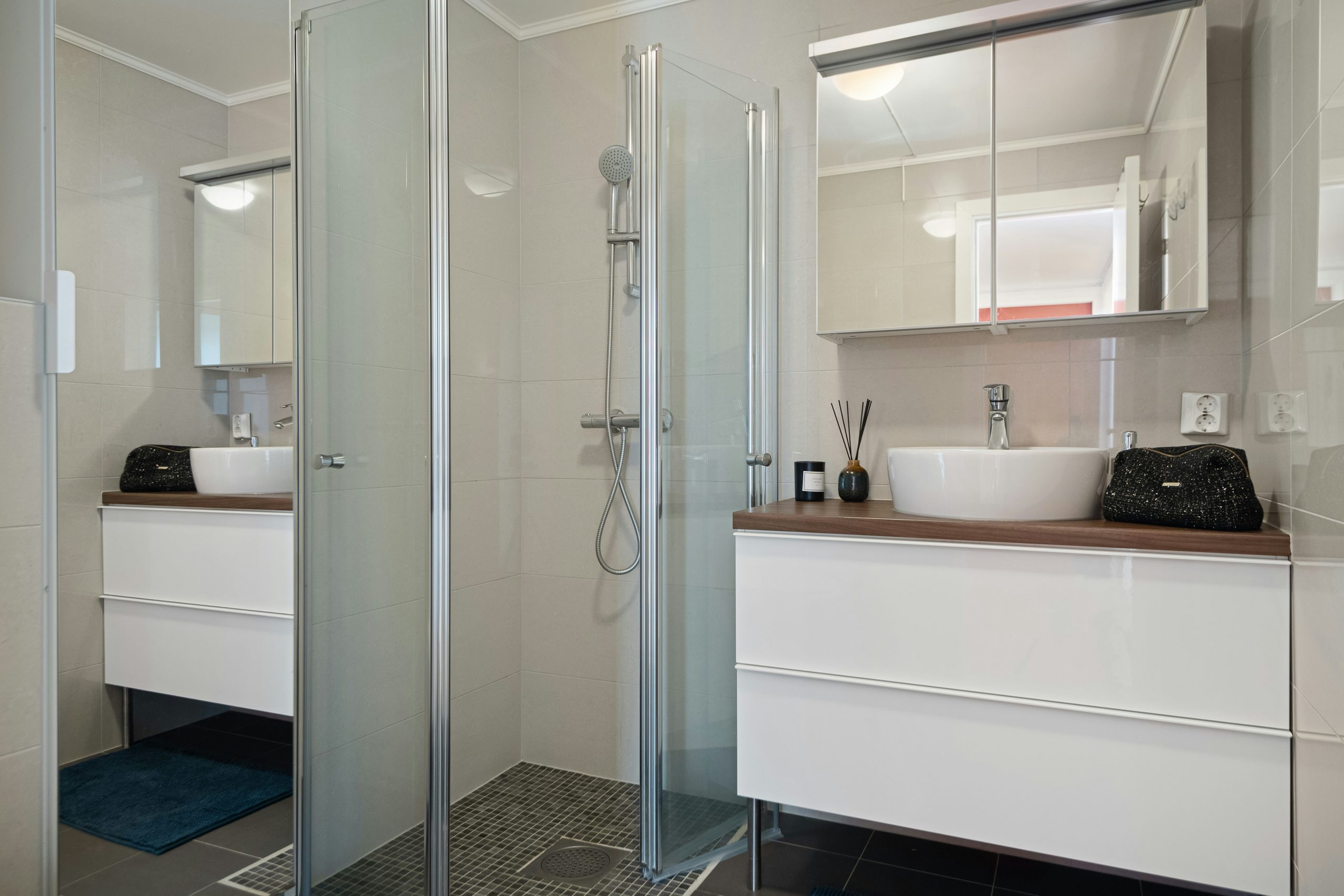 A bathroom with a walk in shower next to a sink