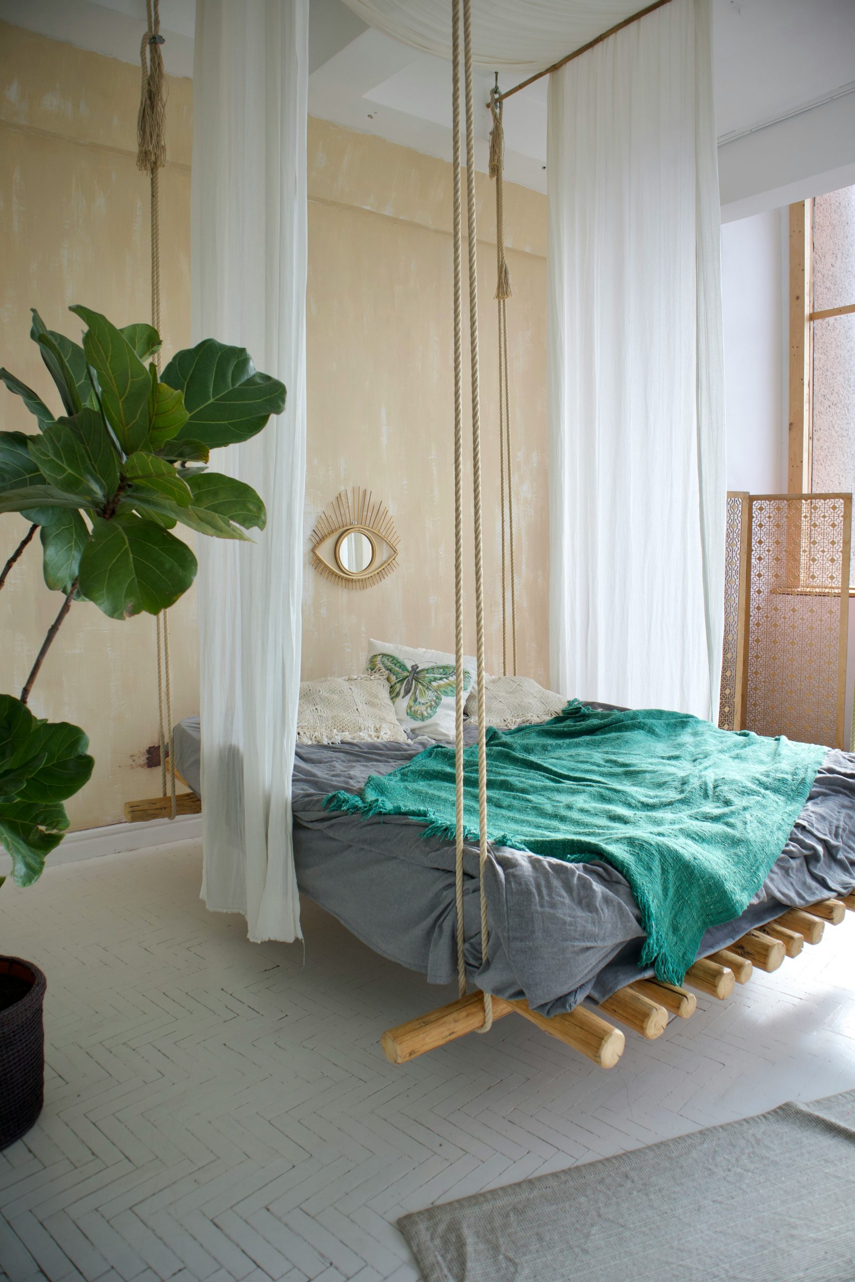 a bedroom with a bed and a plant in the corner