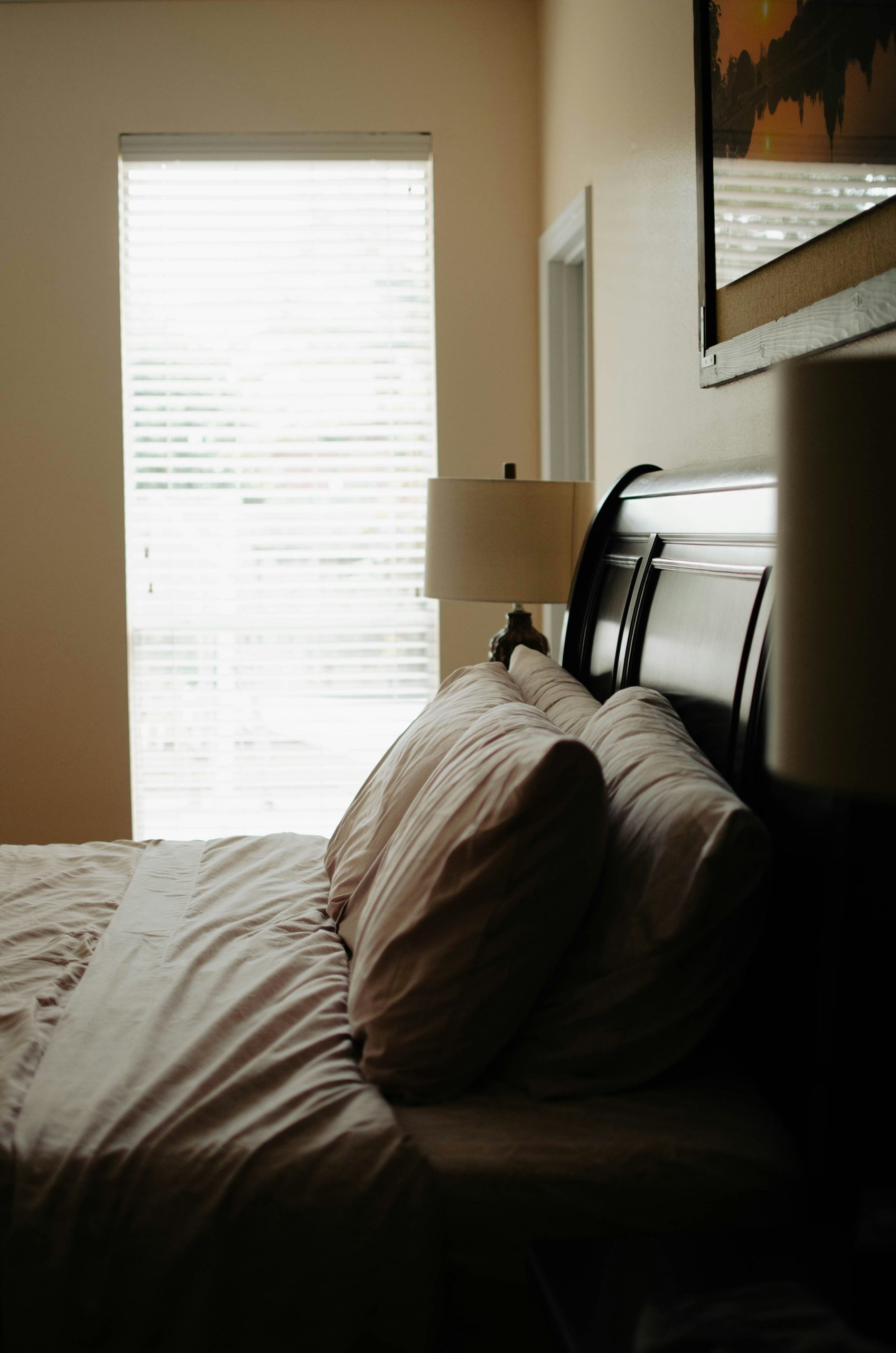 a bedroom with a bed and a window with blinds