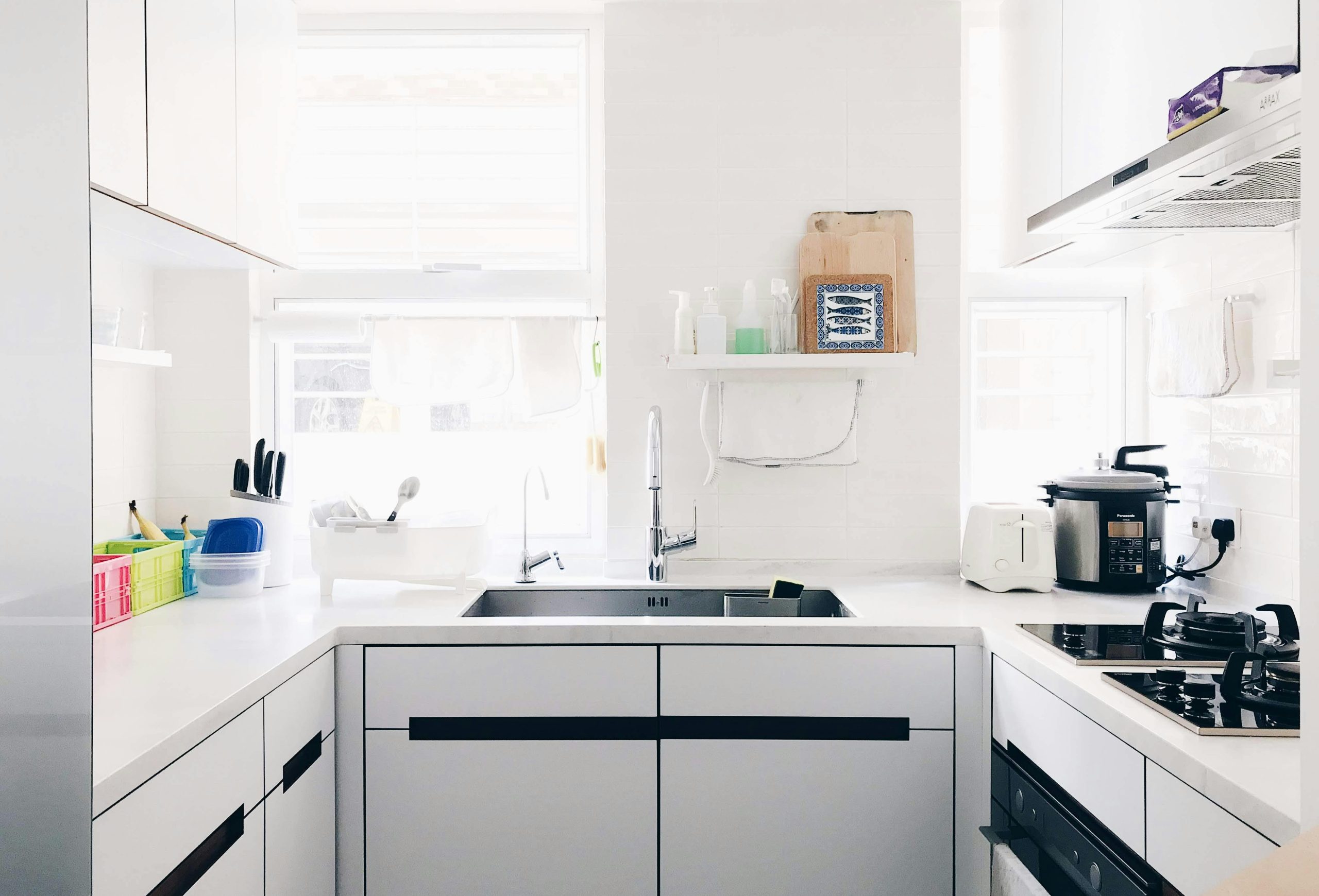 A clean and bright minimalist kitchen with stainless steel appliances and modern design.