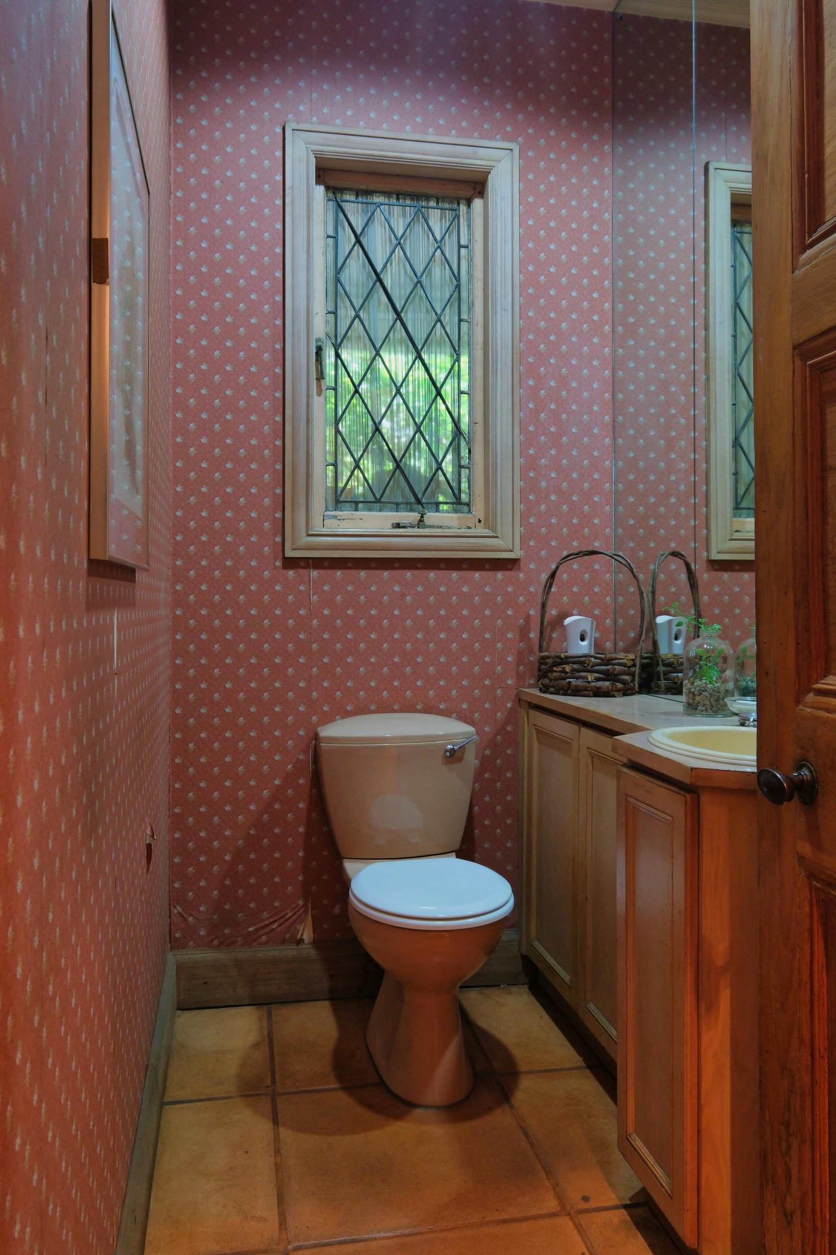 A cozy bathroom with warm lighting, featuring rustic decor and wooden cabinetry.