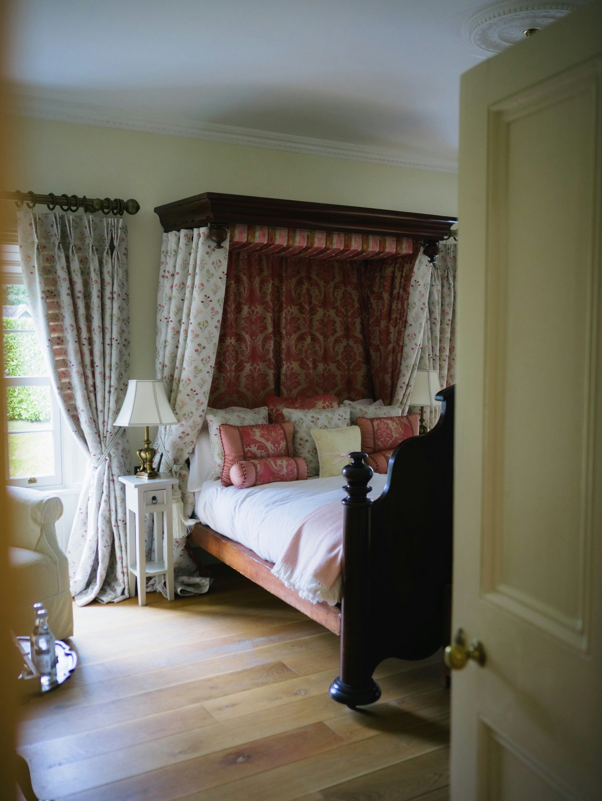 A luxurious bedroom with a four-poster bed and ornate curtains.