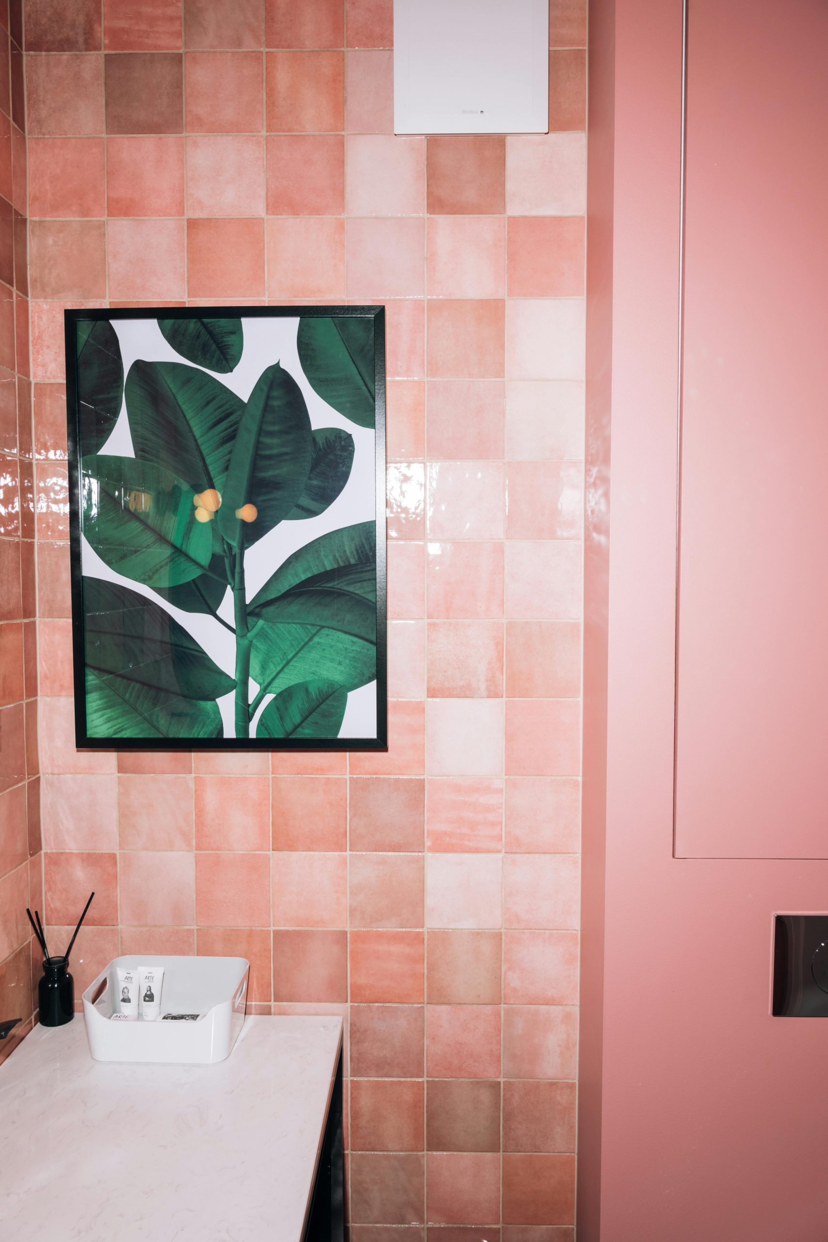 A luxury pink bathroom featuring a botanical painting and modern decor.