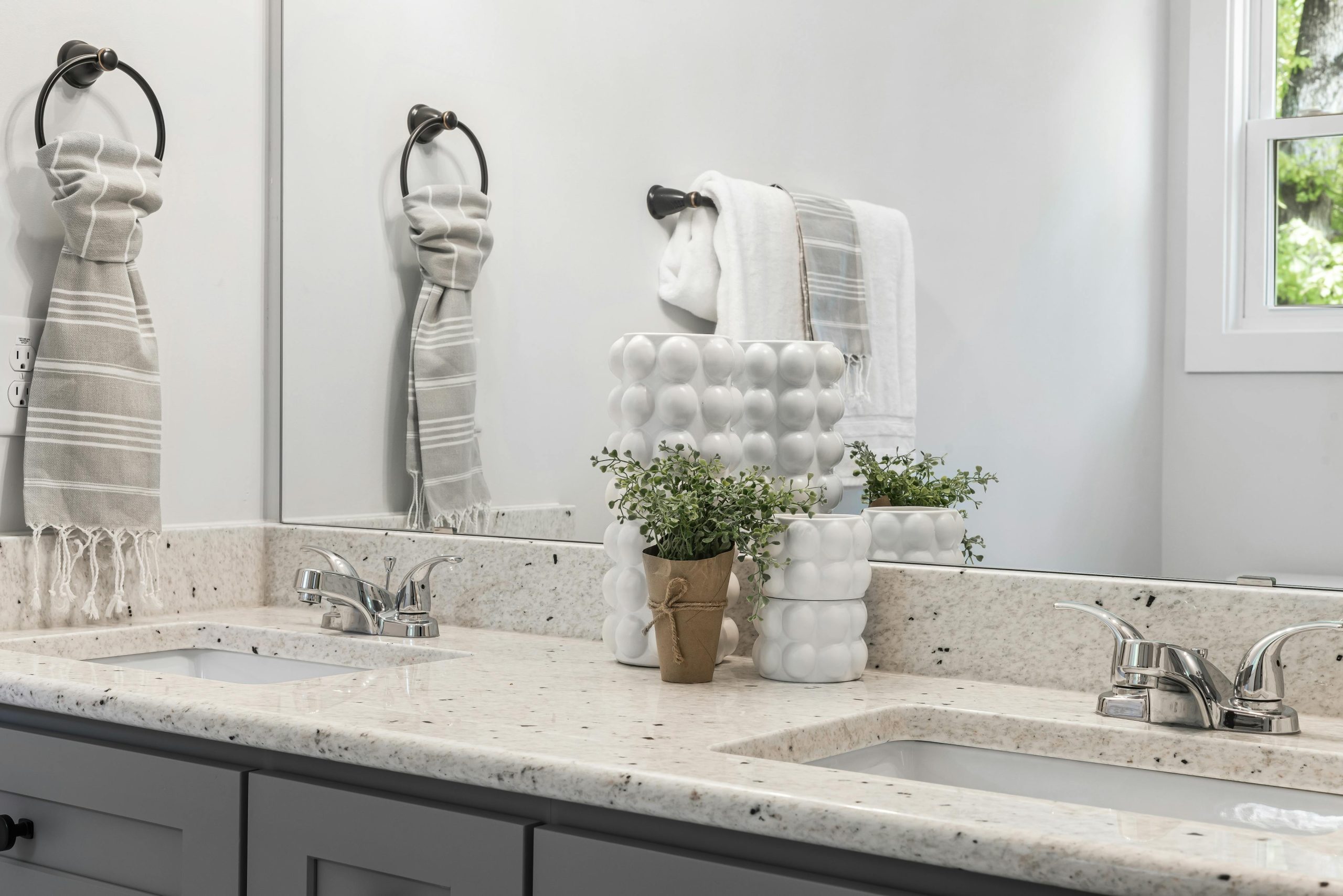 A minimalist bathroom with double sinks, modern fixtures, and stylish decor.