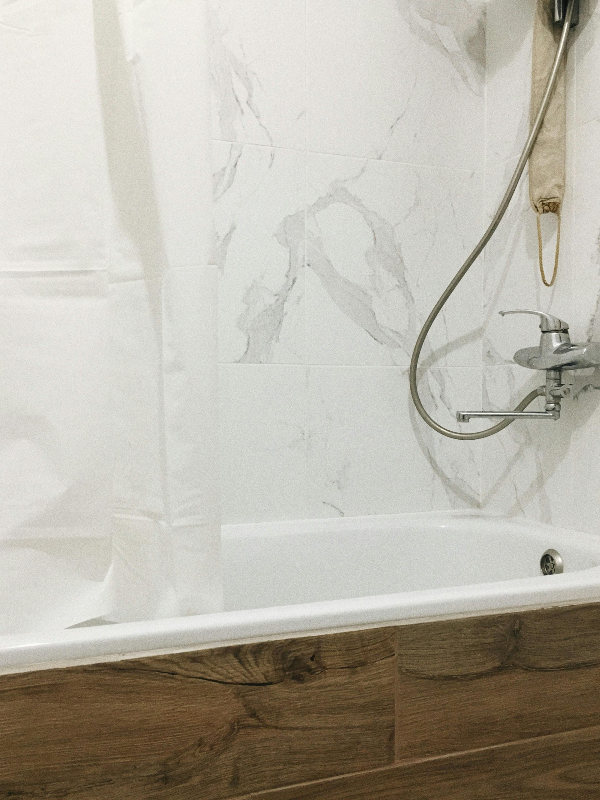 A modern bathroom with marble tiles, bathtub, and minimalist fixtures, perfect for home decor inspirations.
