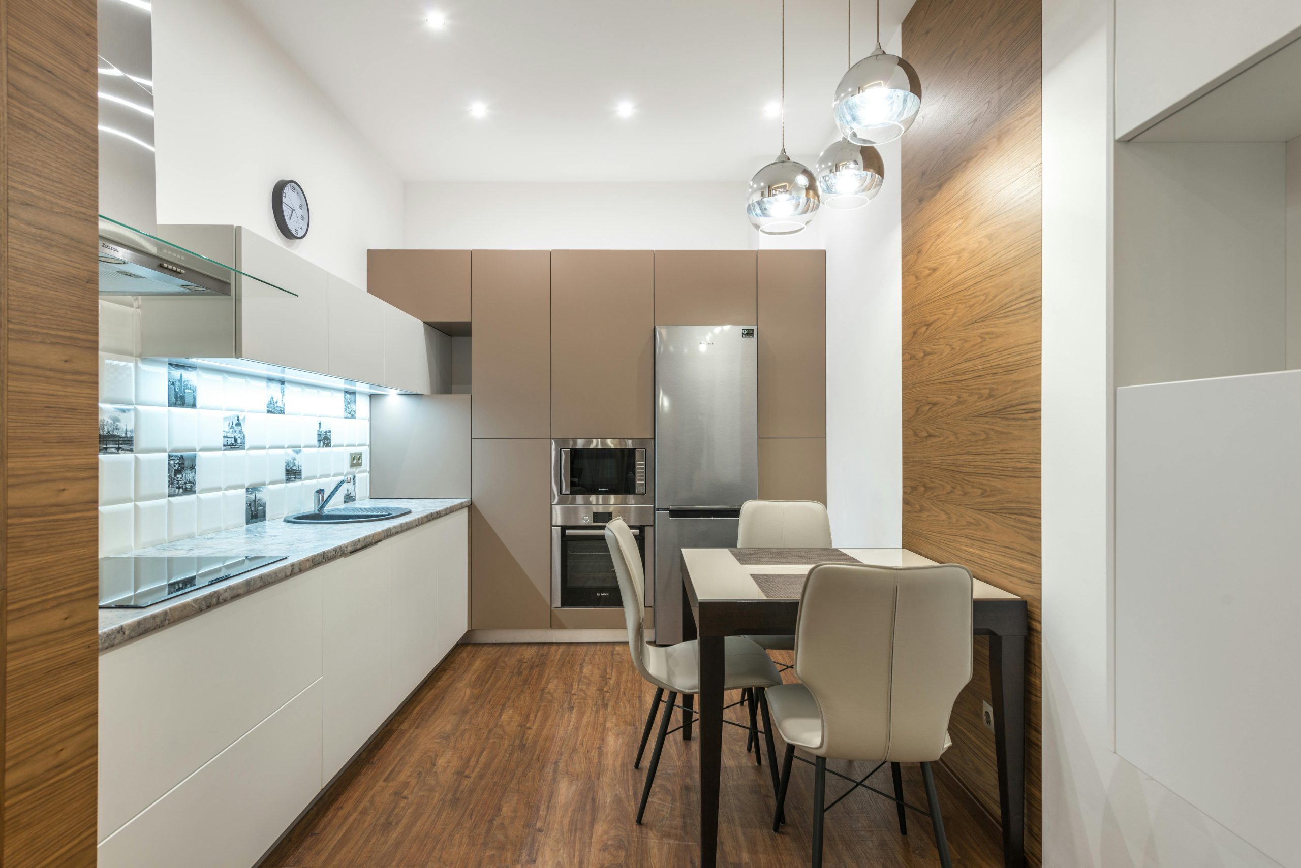 A sleek, modern kitchen featuring beige cabinets and wooden elements.