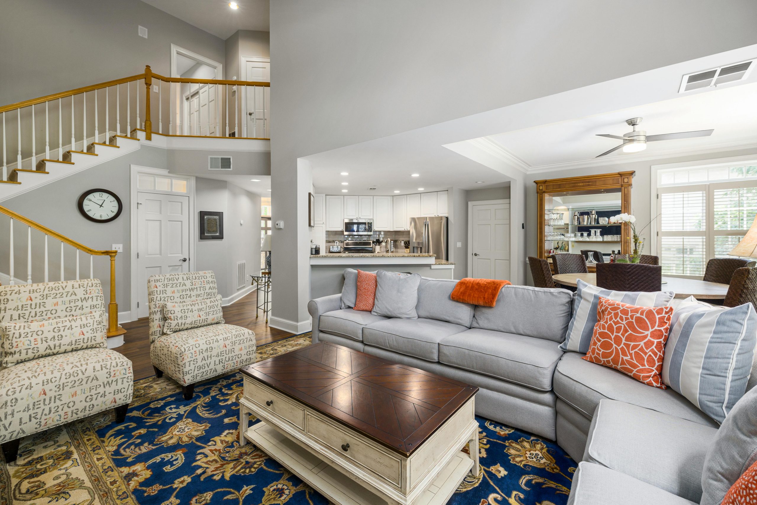 A stylish modern living room with a cozy sofa and open kitchen layout.