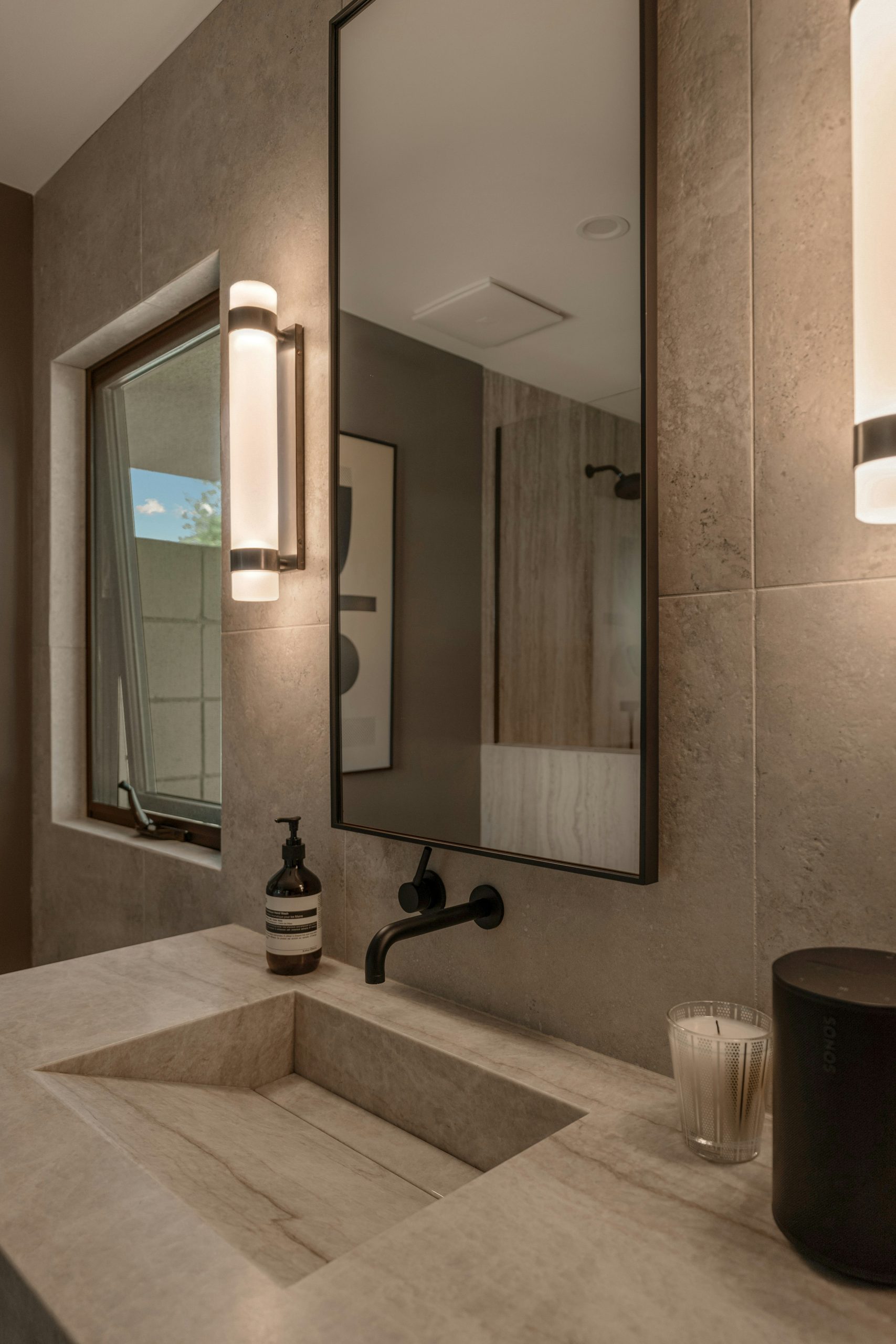 An elevated Palm Springs bathroom remodel blending natural stone, warm wood cabinetry, and spa-inspired lighting. Shot for an architectural designer to showcase luxury renovation details.
