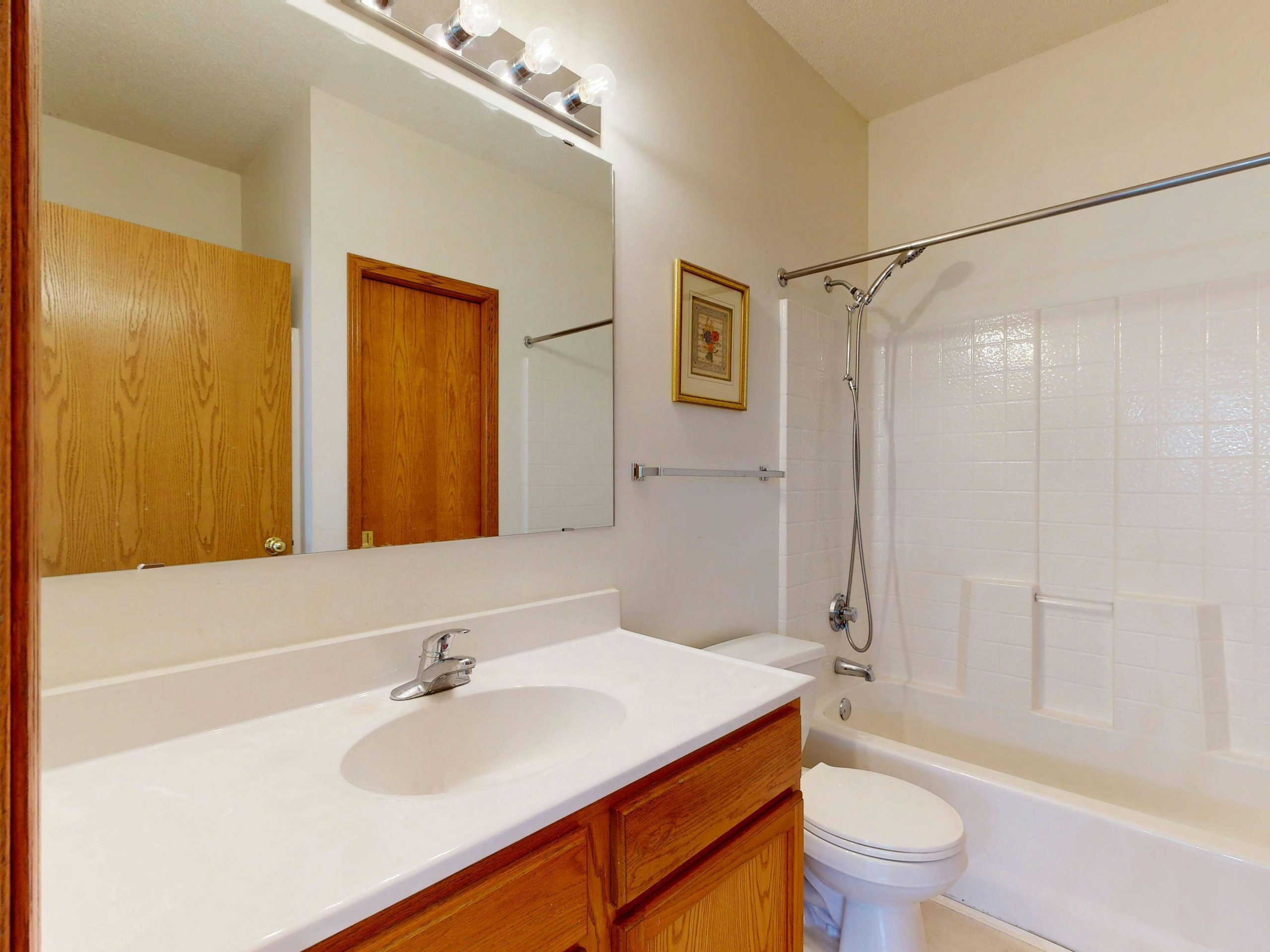 Bright and clean bathroom with wooden cabinetry and modern fixtures.