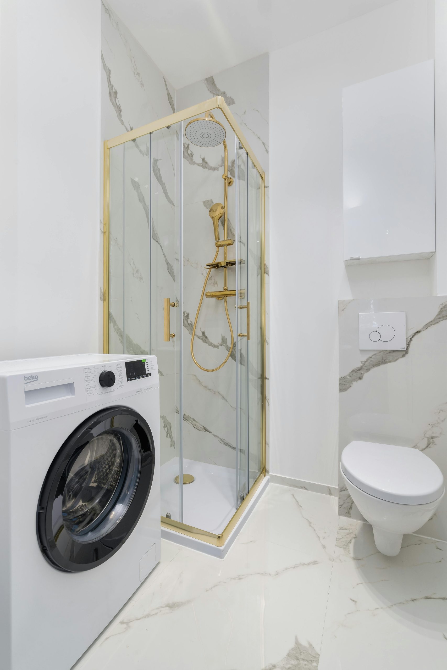 Bright and elegant bathroom featuring a luxury shower, toilet, and washing machine.