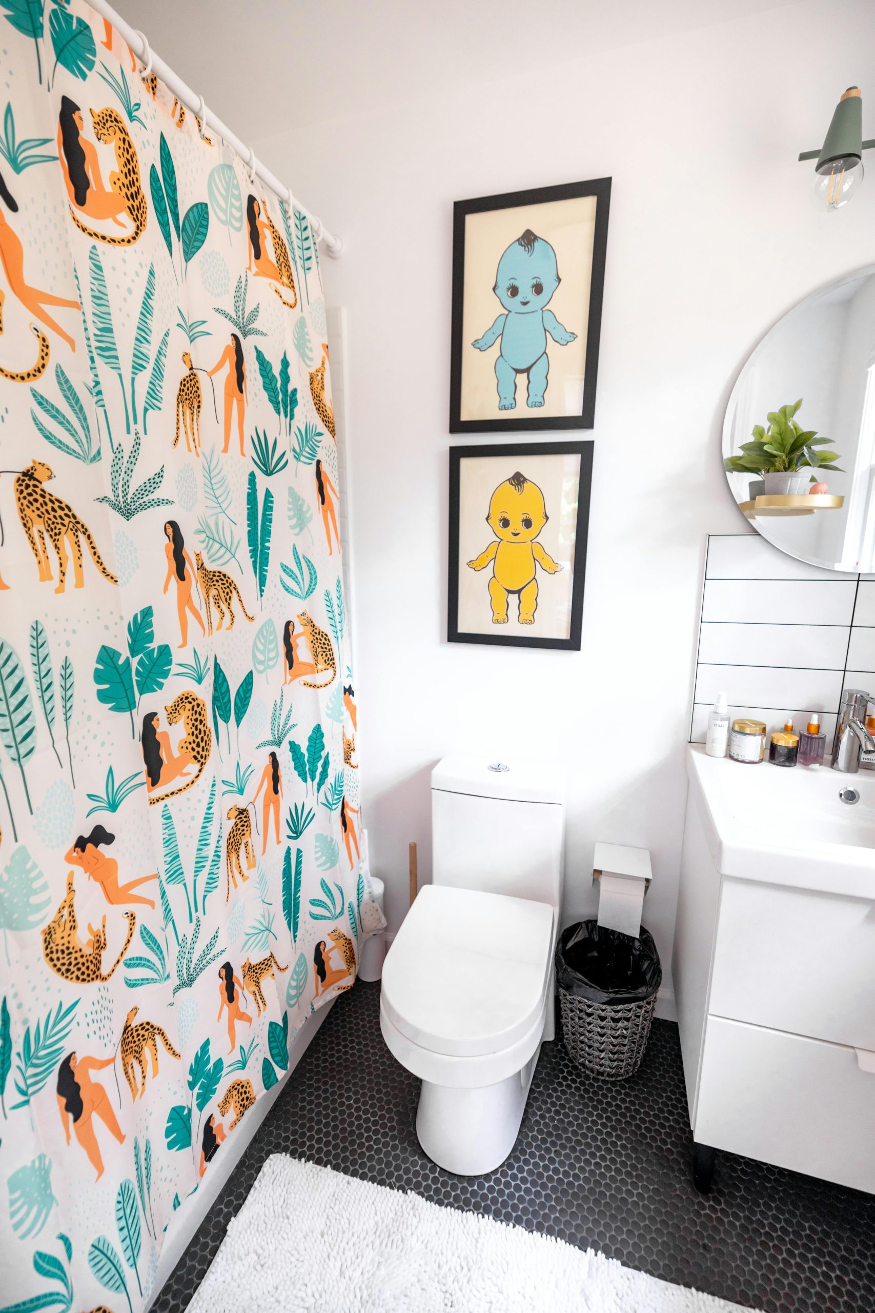 Bright and playful bathroom design with vibrant shower curtain and art prints.