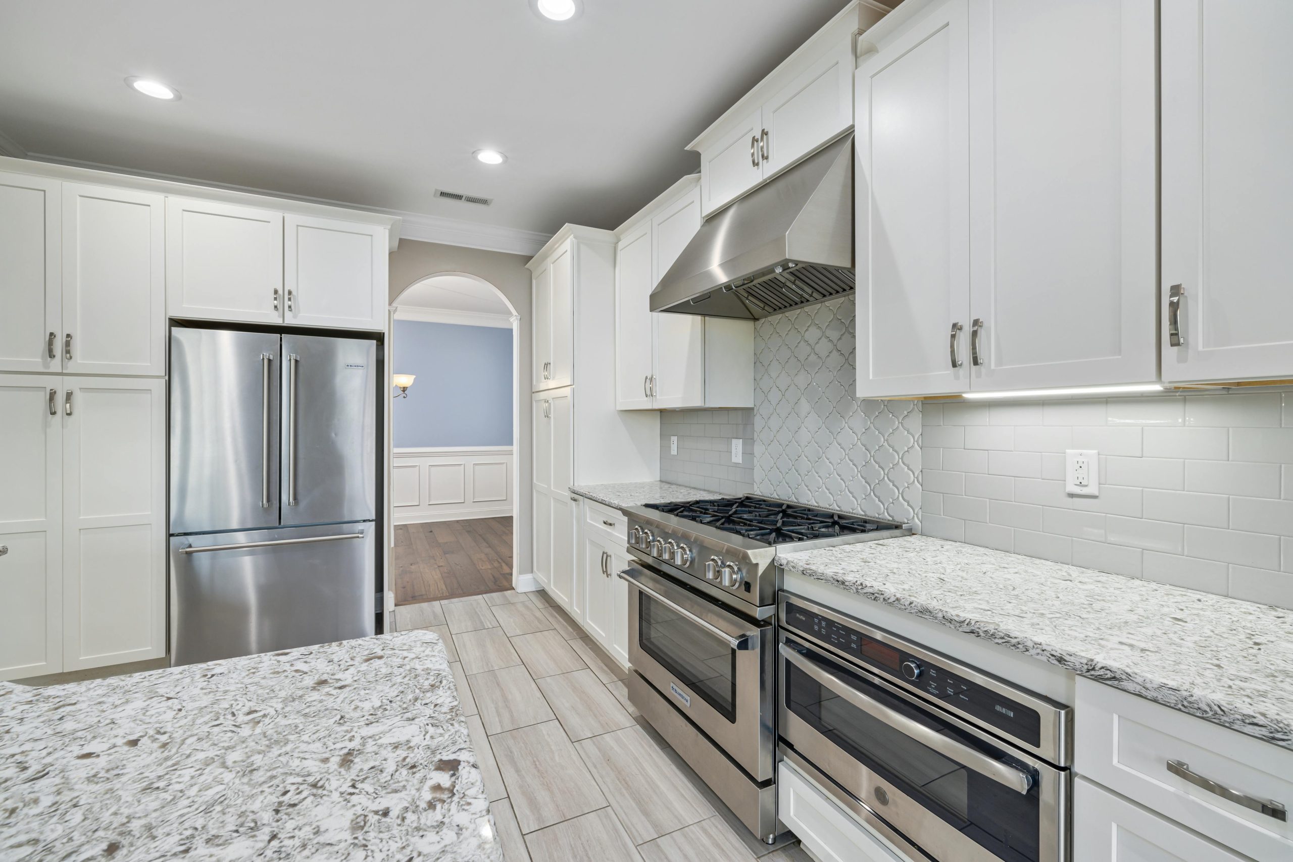 Bright and spacious contemporary kitchen with sleek appliances and marble countertops.