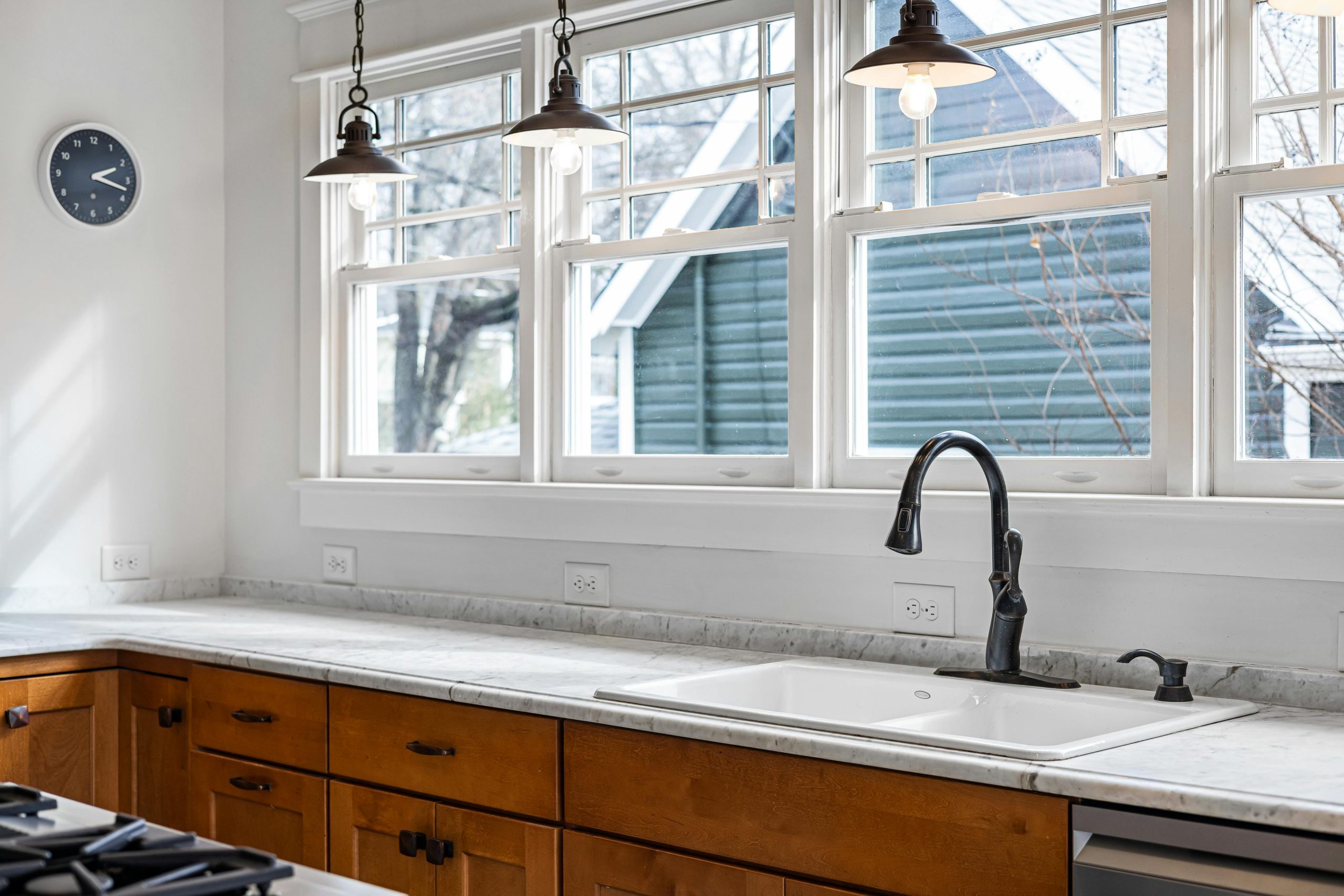 Bright kitchen featuring marble countertops, stylish lighting, and scenic windows.