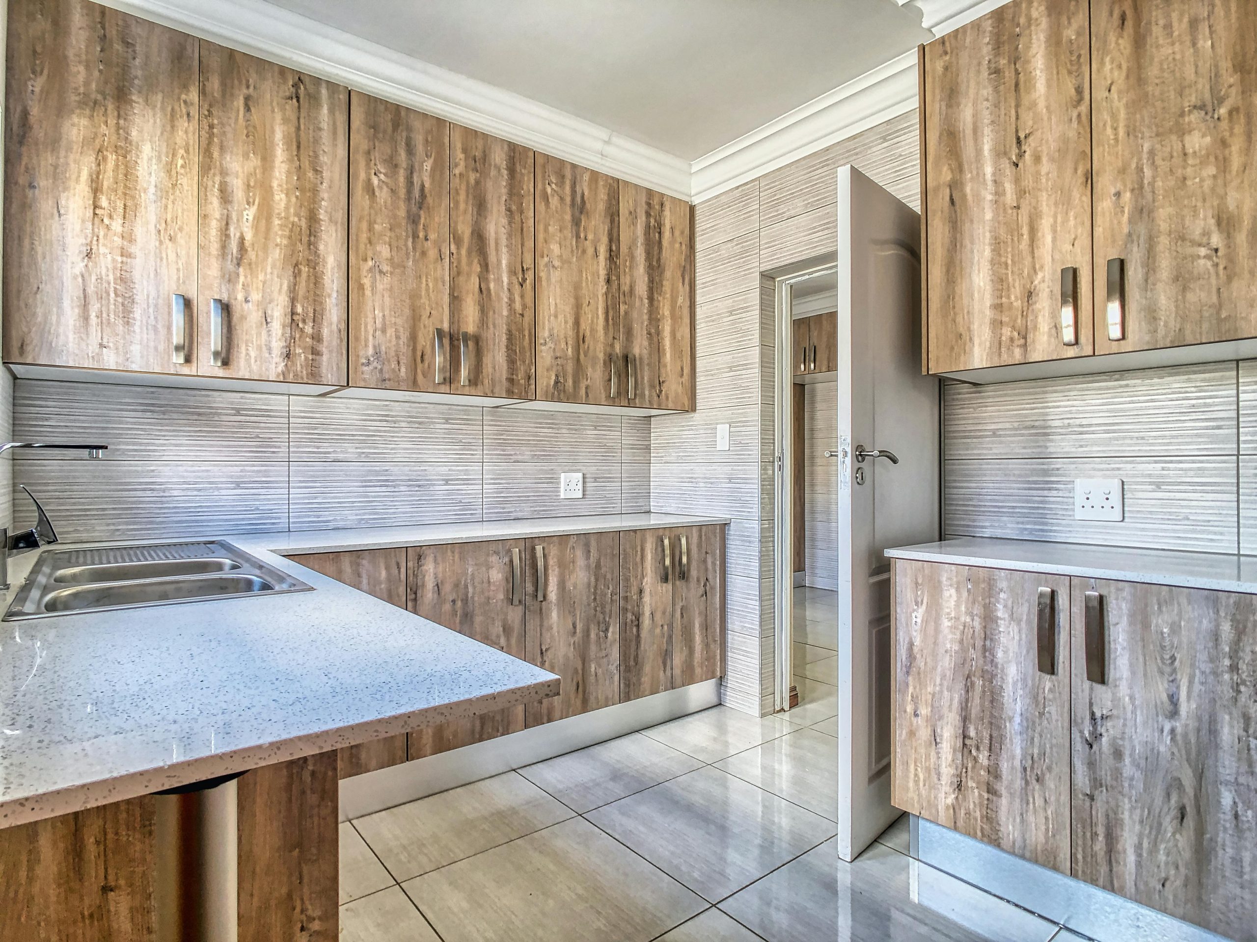 Bright kitchen interior featuring wood cabinets and quartz countertops with modern design.