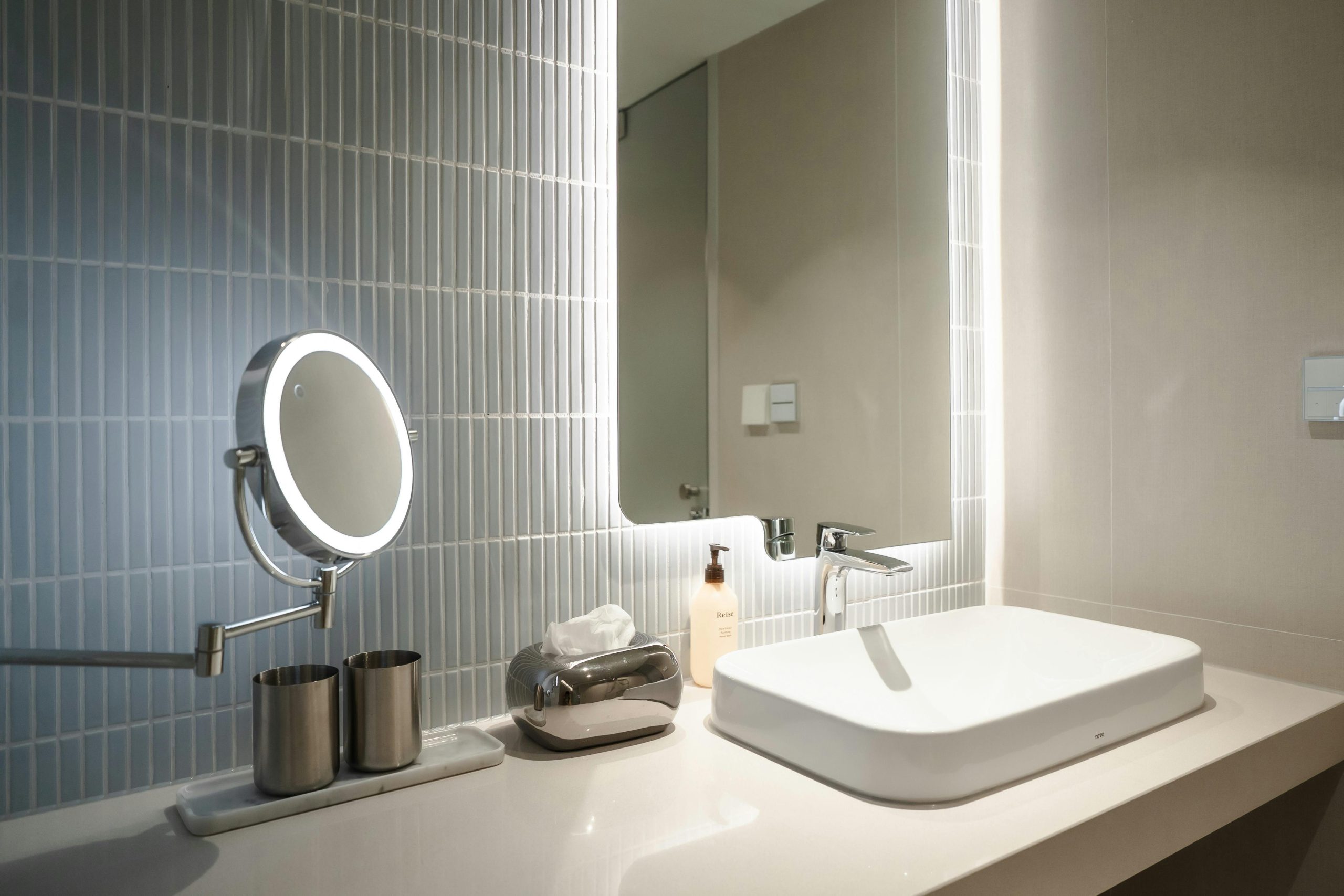 Clean and stylish bathroom vanity with an illuminated mirror reflecting modern design.